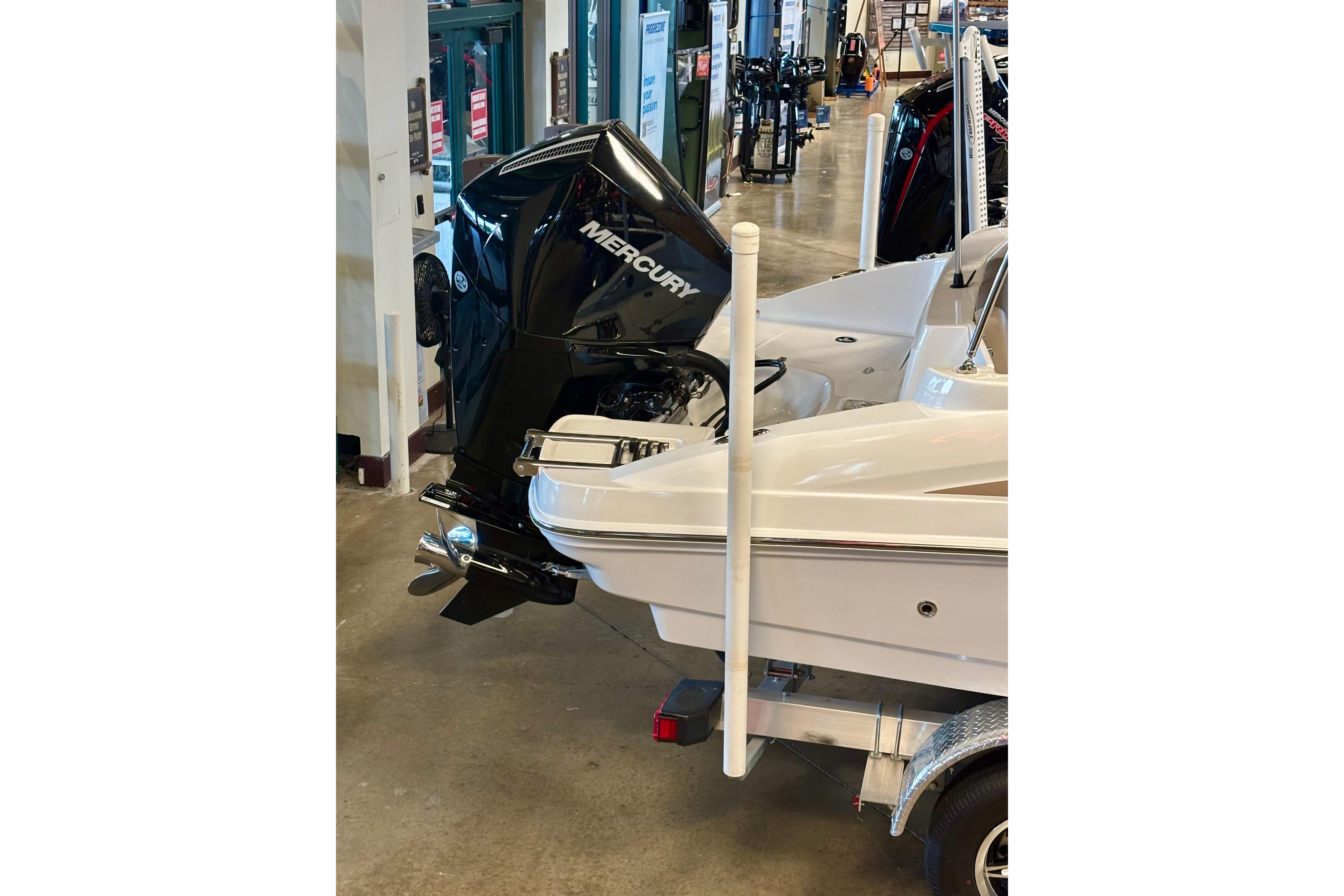2026 Tahoe 2150 boat with Mercury outboard motor displayed indoors.