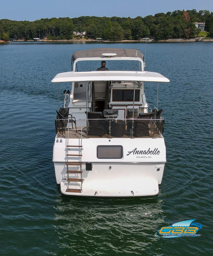 1989 Carver 3807 Aft Cabin yacht on serene lake, rear view.