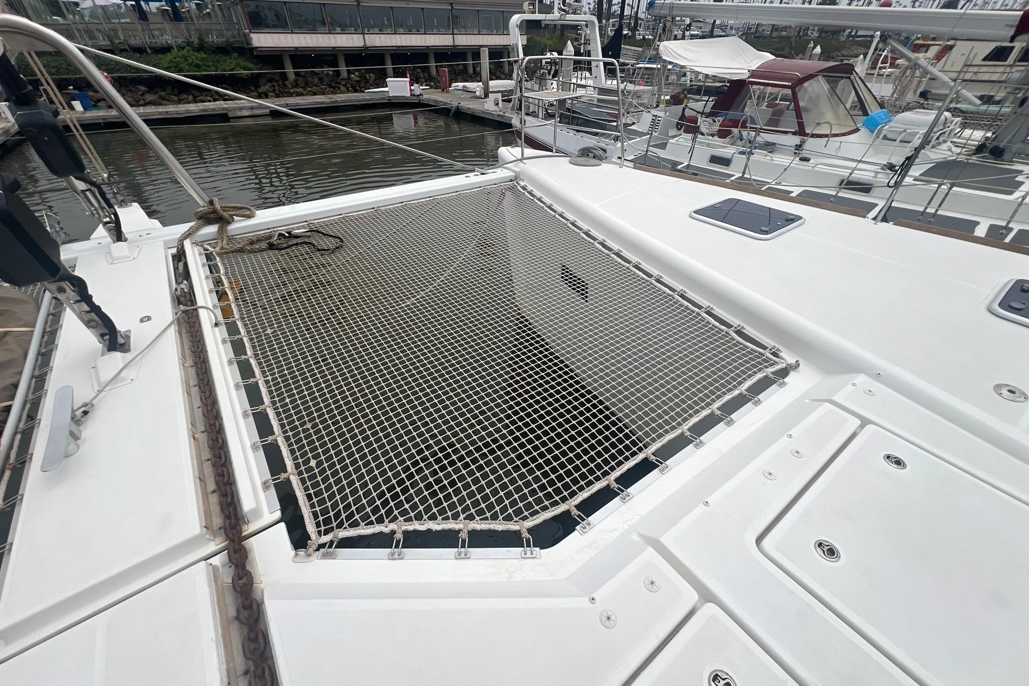 2019 Lagoon 620 catamaran with netting on deck, docked at marina.