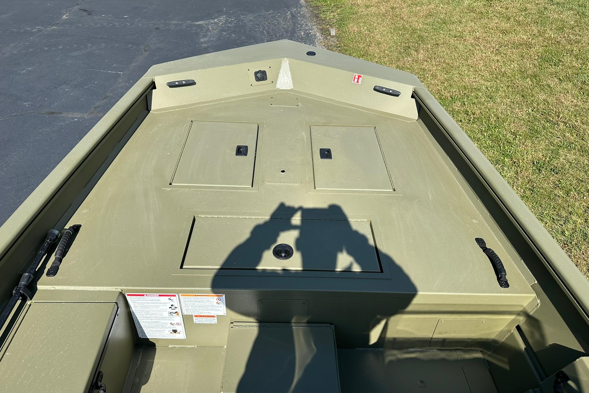 2026 Lowe Roughneck 1860SC boat interior with storage compartments, photographed outdoors.