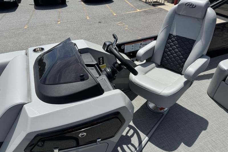 2026 Manitou Encore 25 SL SHP boat cockpit with steering wheel and captain's chair.