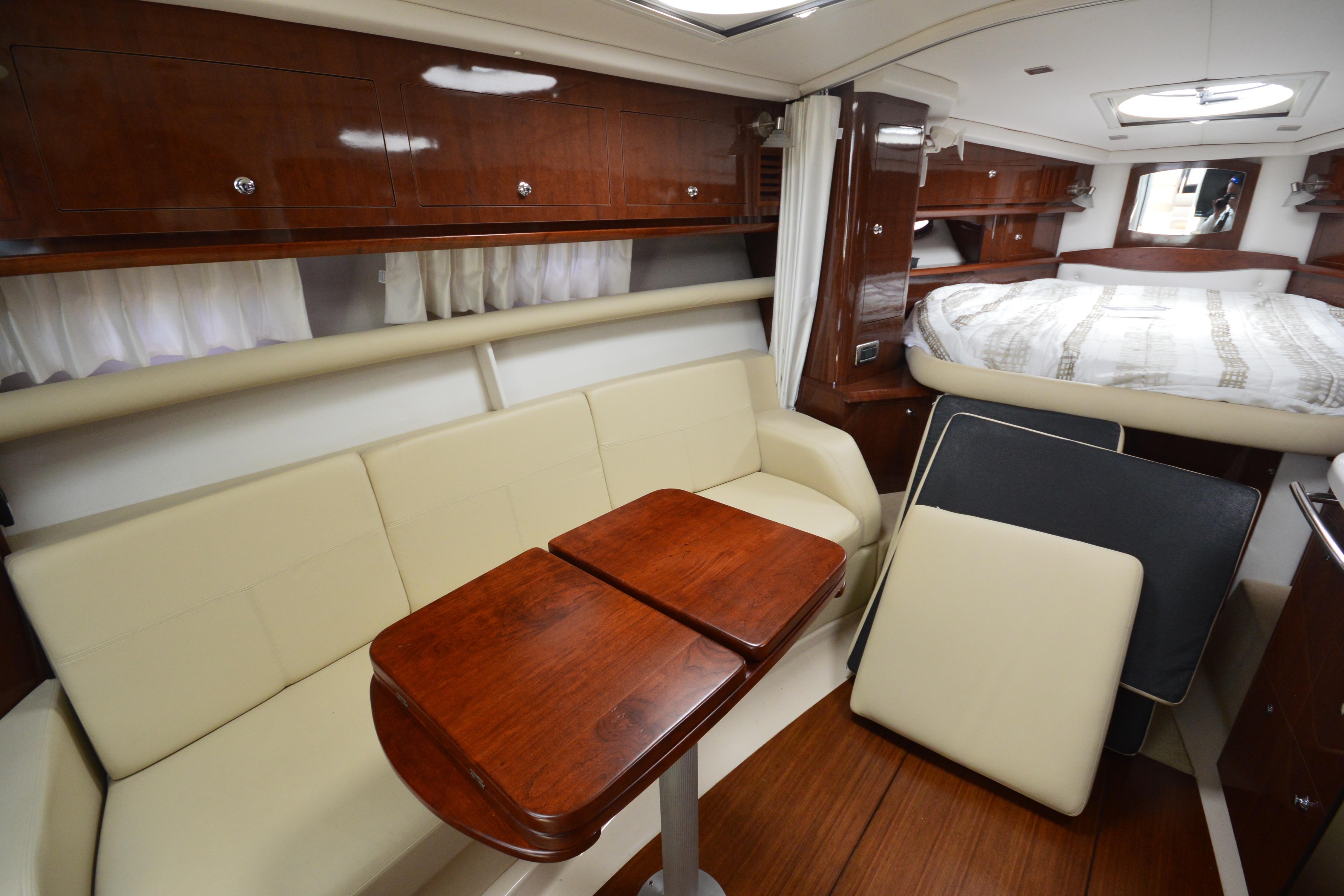 Interior of 2013 Four Winns V375 yacht with elegant seating and wooden table.