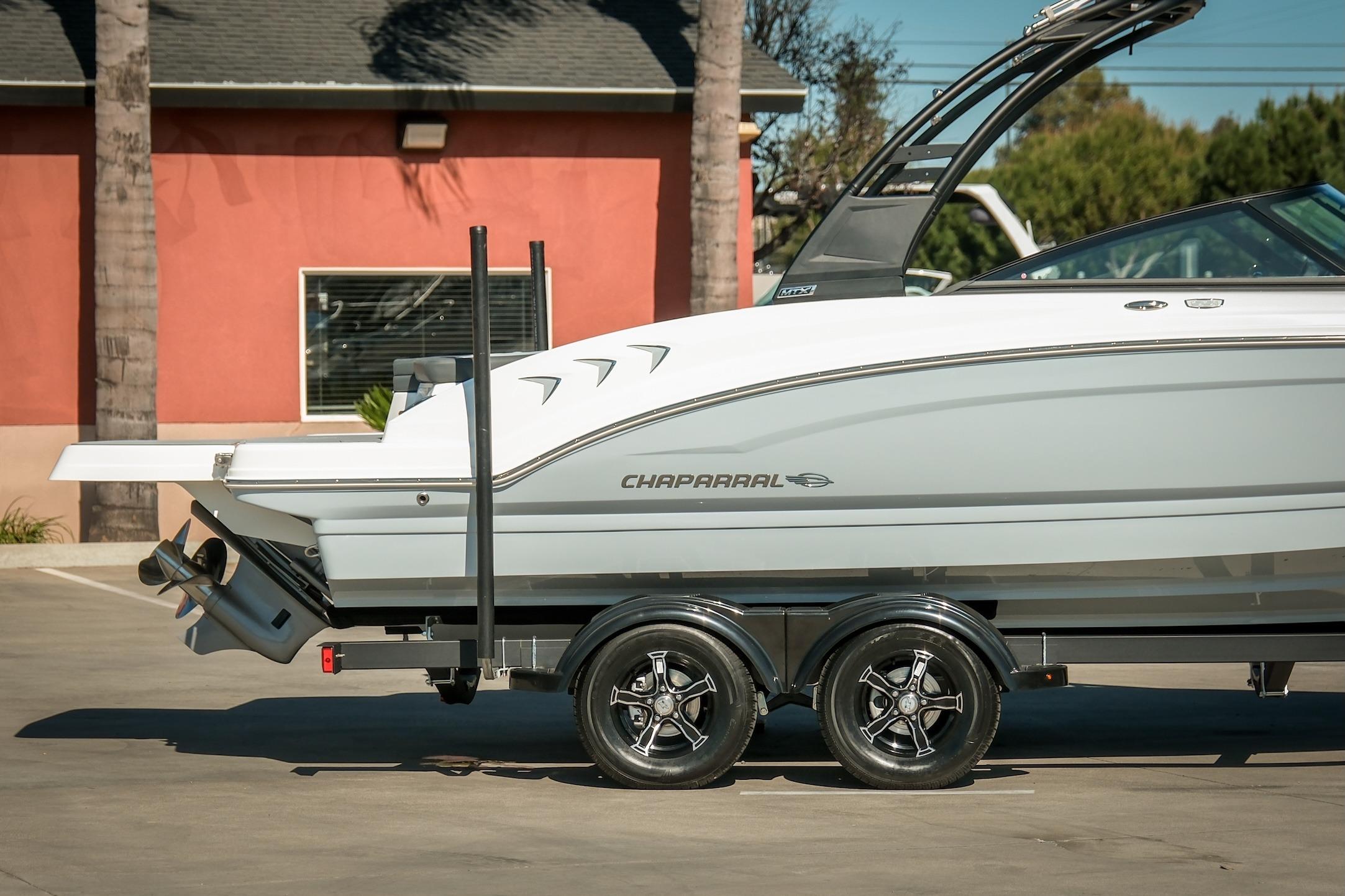 2026 Chaparral 23 SSi boat on trailer, parked outdoors, showcasing sleek design and modern features.