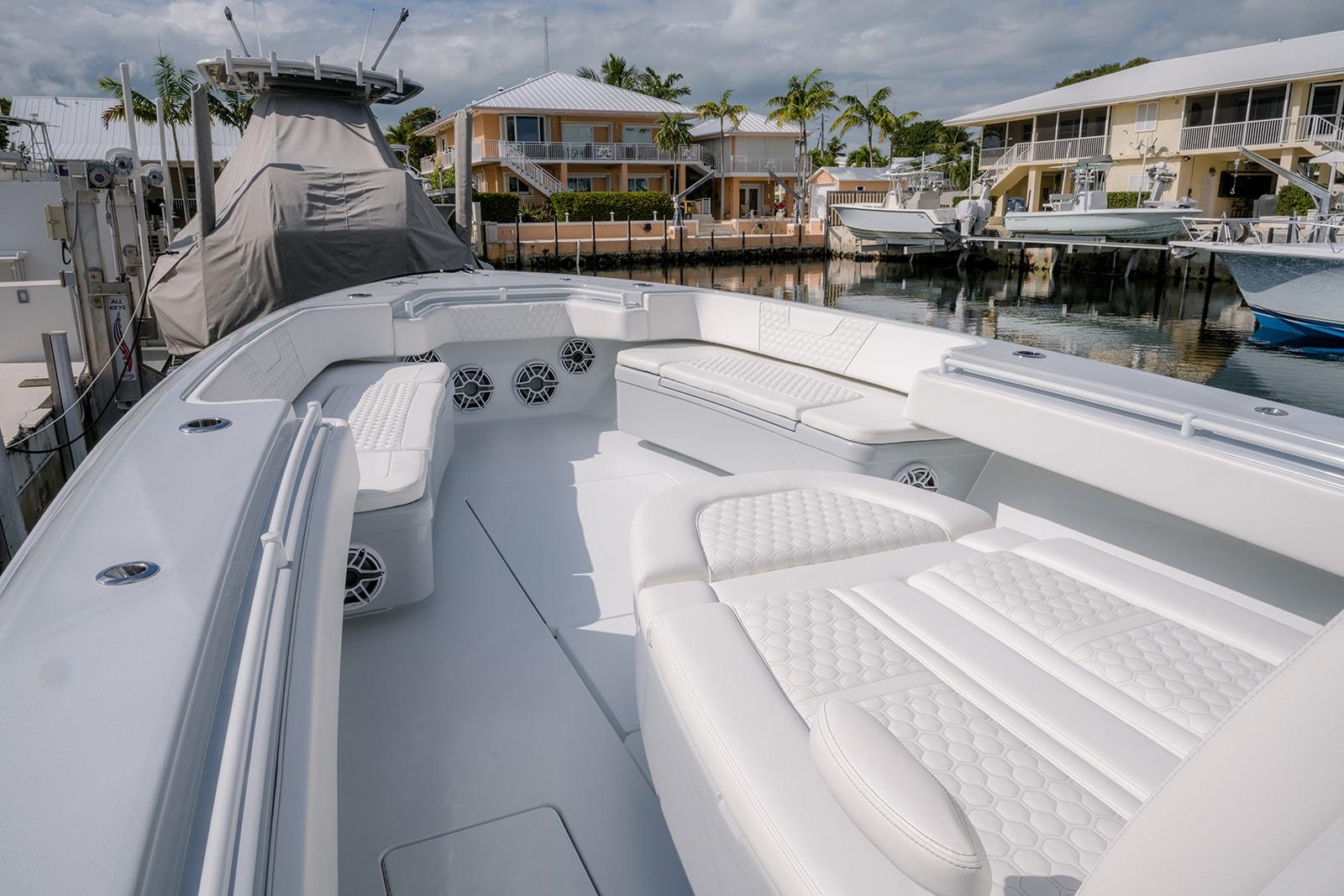 2024 Contender 44 ST boat with luxurious white seating in a marina setting.