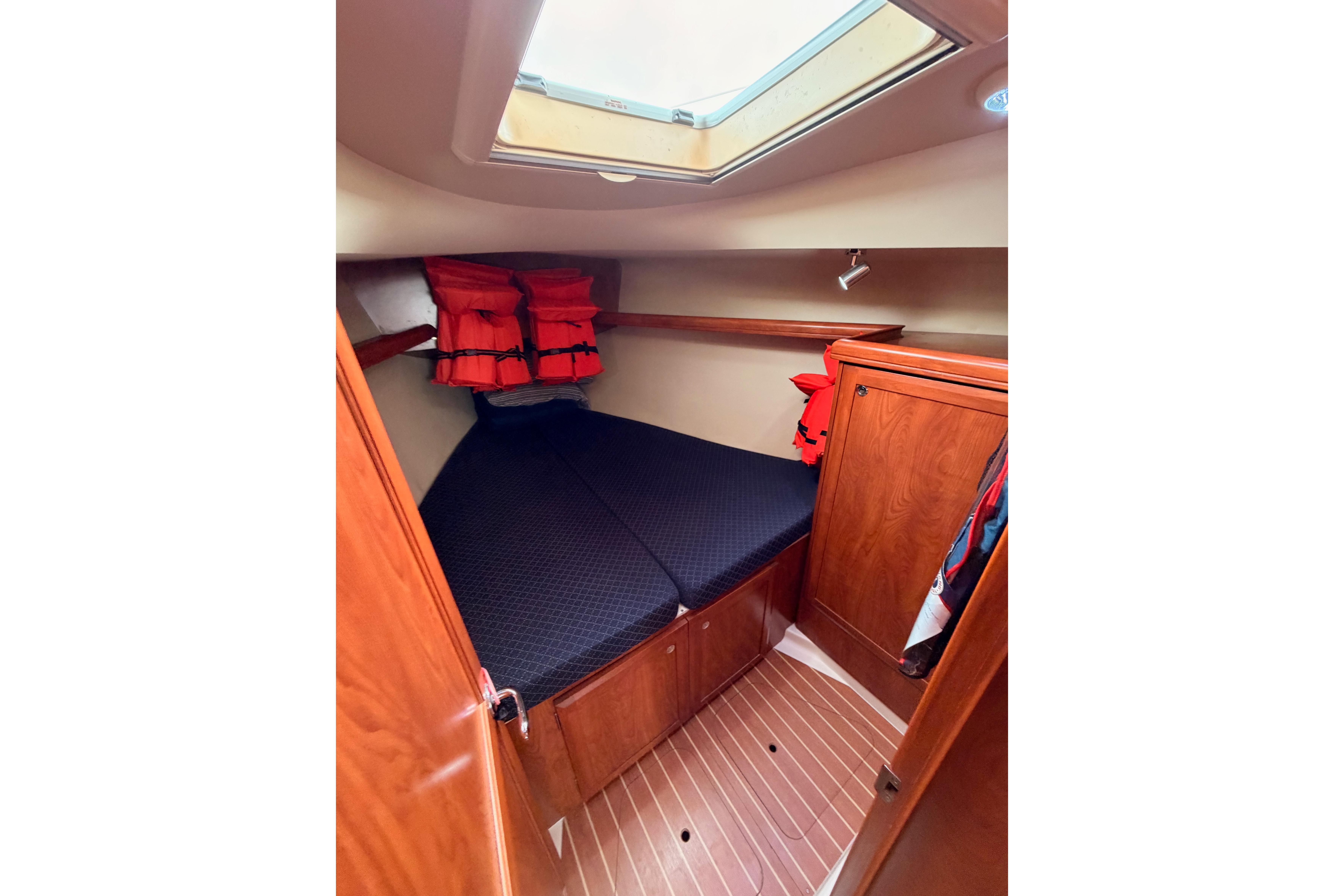 2009 Hunter 38 yacht cabin with skylight, wooden interior, and life jackets.
