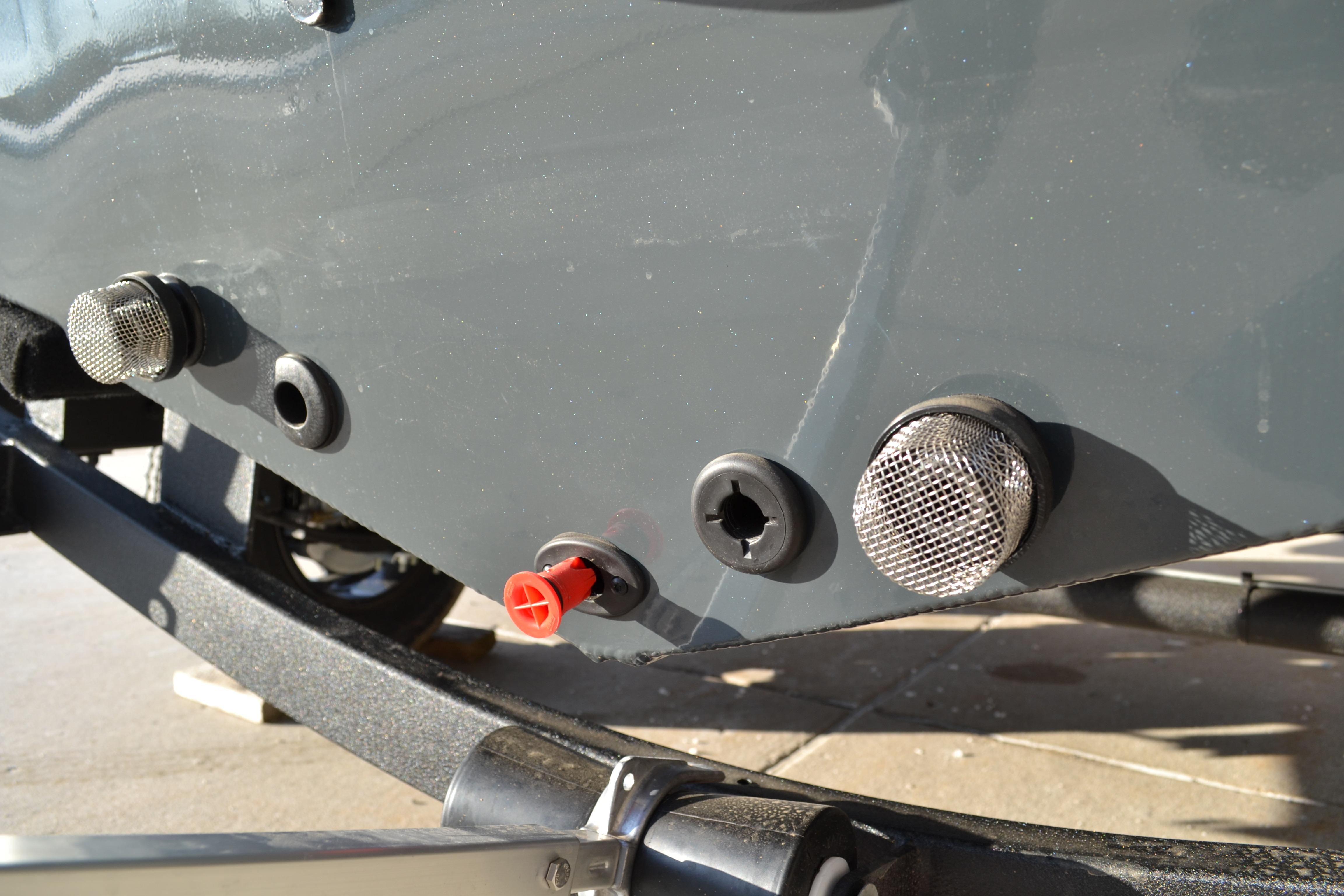 Close-up of 2026 Ranger VS1882SC Reata boat hull with fittings and drain plugs.