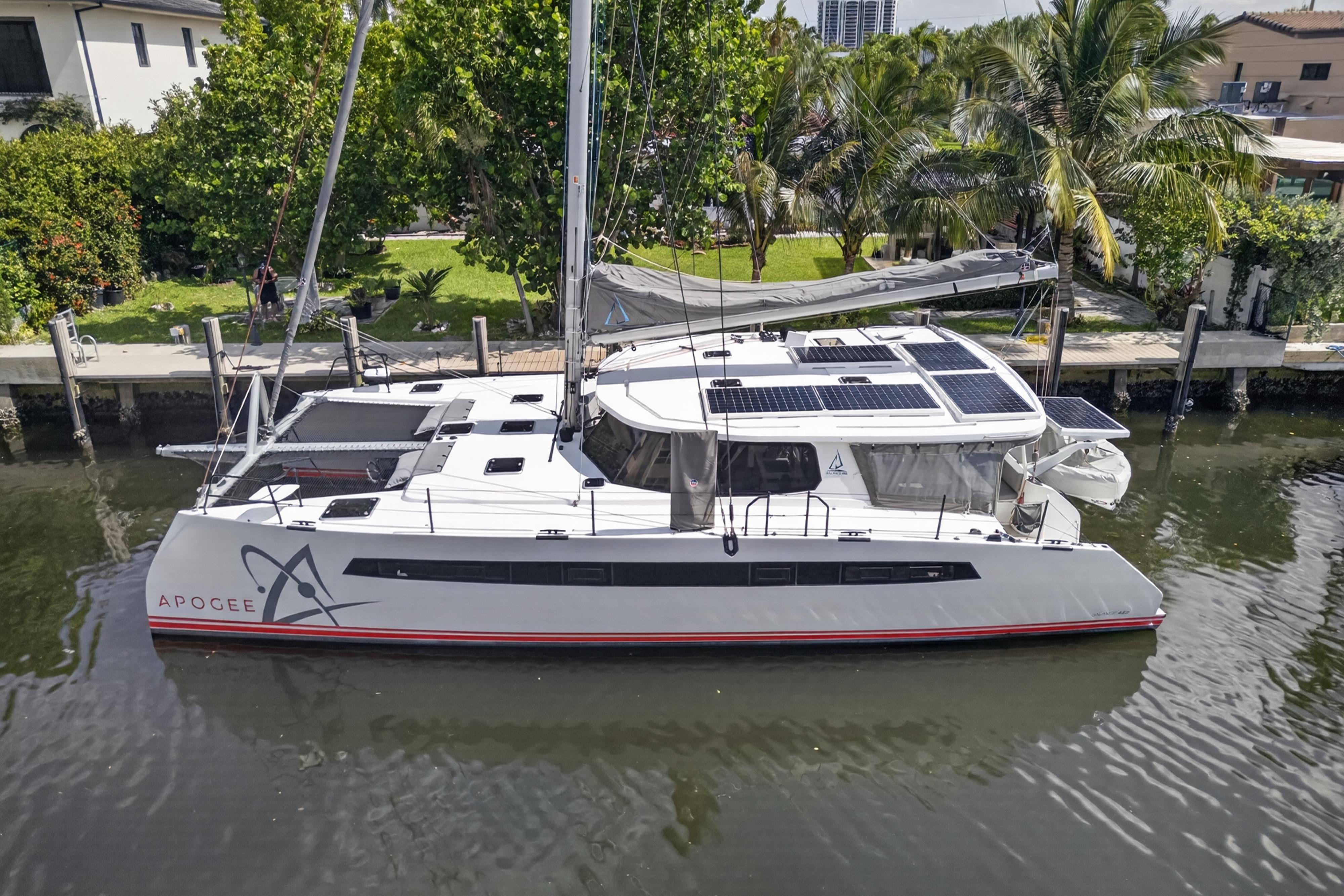Modern Balance 482 catamaran docked by lush greenery, featuring solar panels, 2023 model.