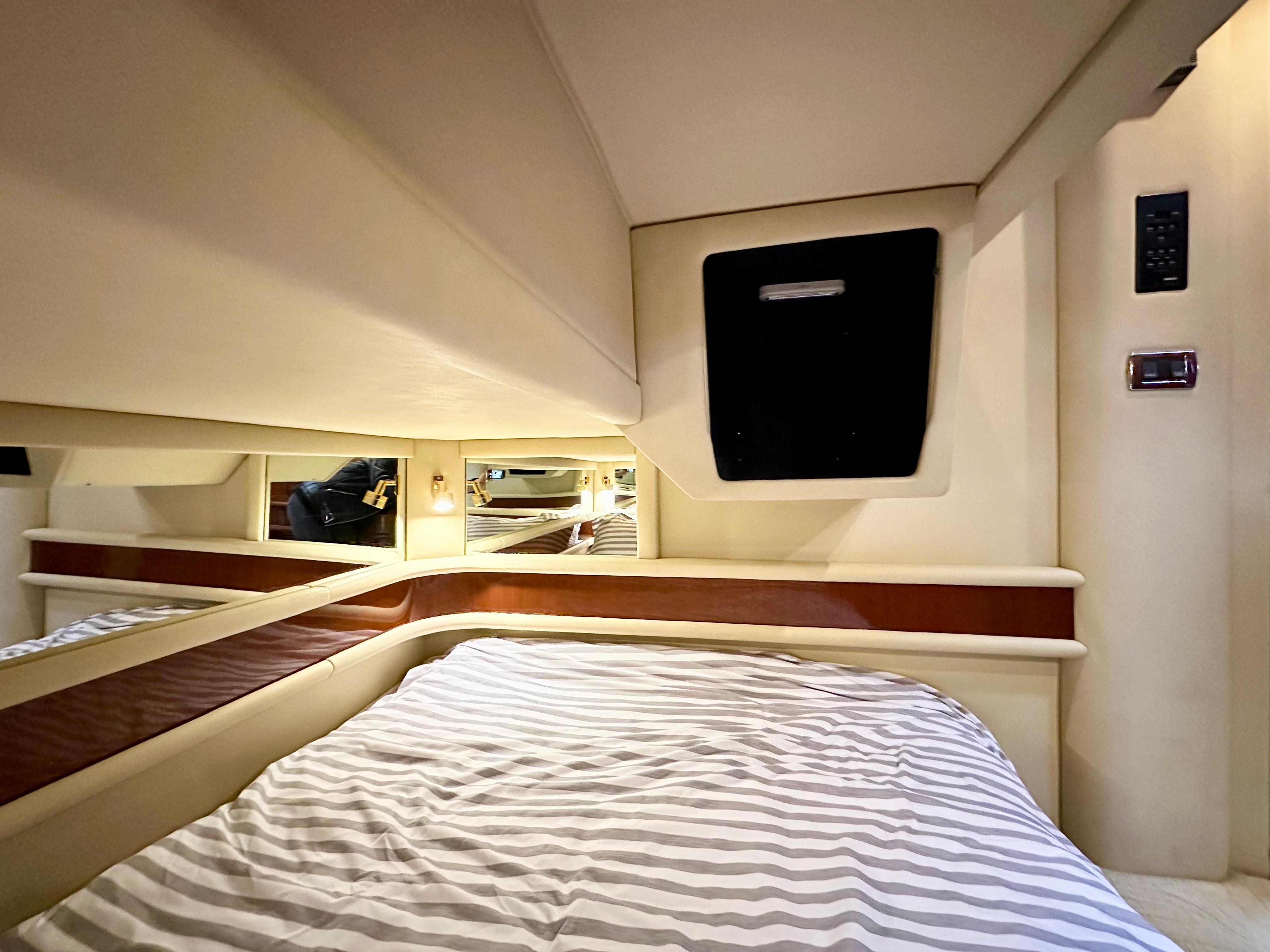 Luxurious cabin interior of 2002 Sea Ray 560 Sedan Bridge yacht with striped bedding.