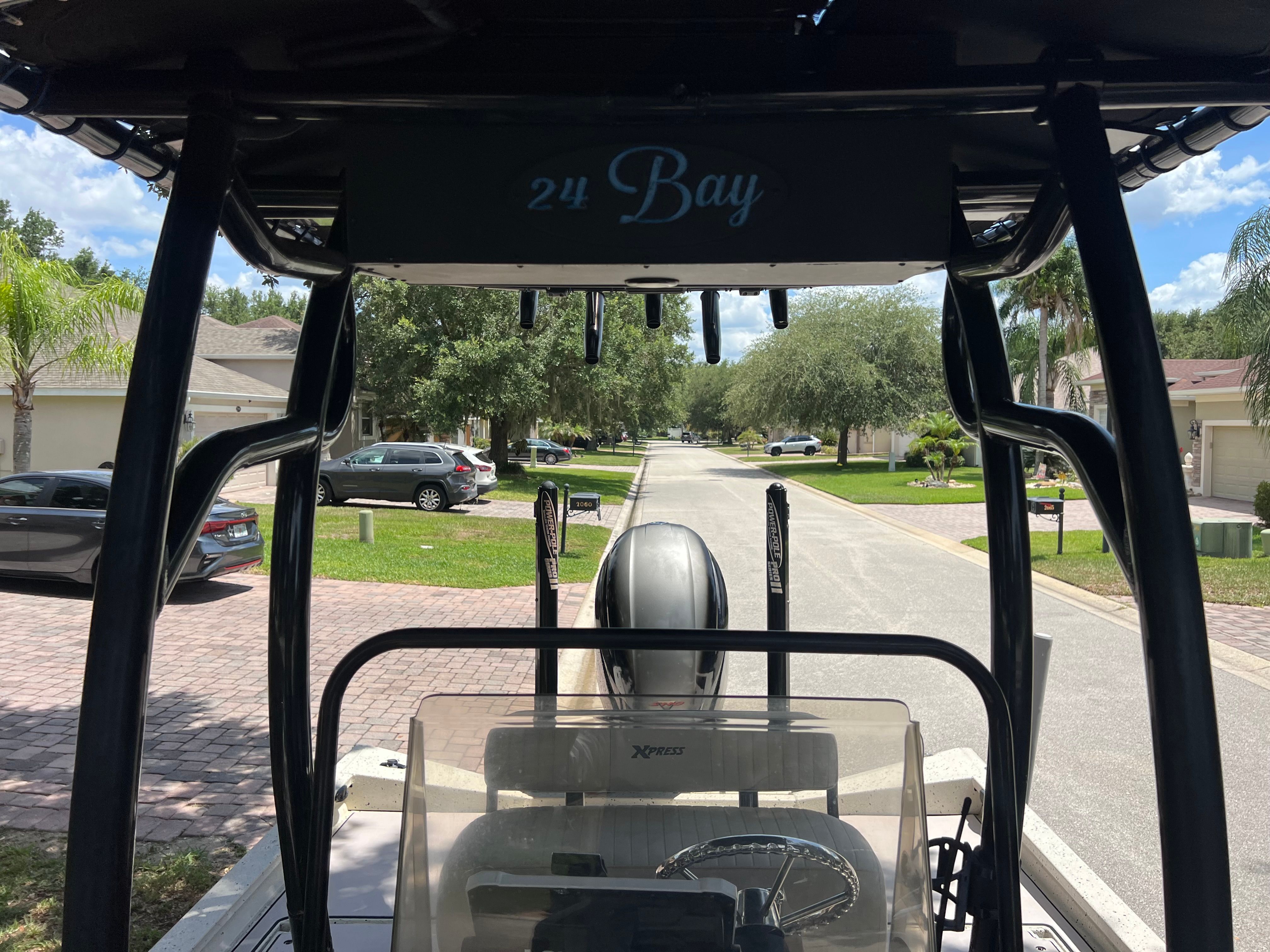 Xpress H24B Bay boat on trailer in residential area.