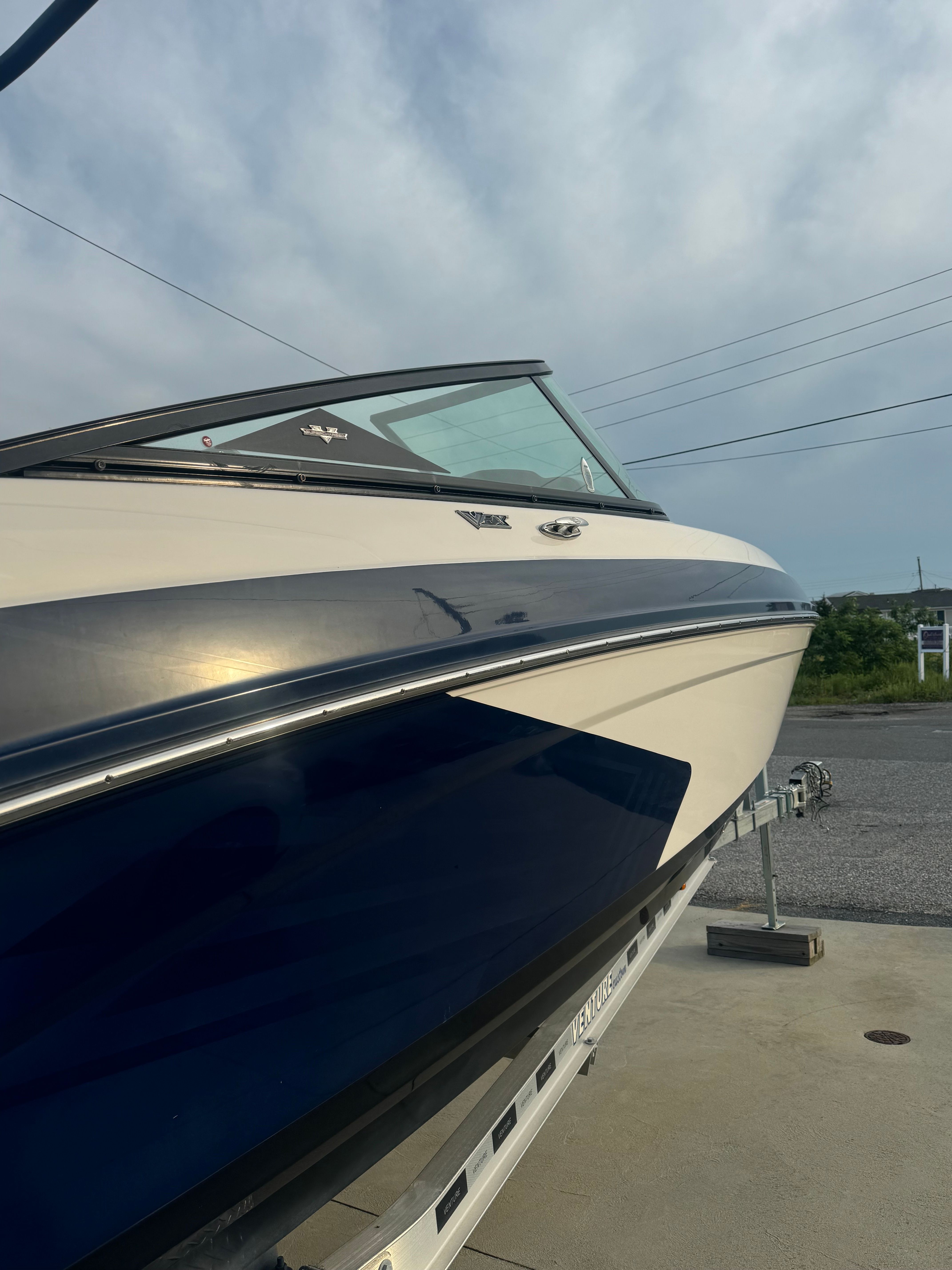 A 2016 Chaparral Vortex 243 VRX on a trailer. The sky is cloudy.