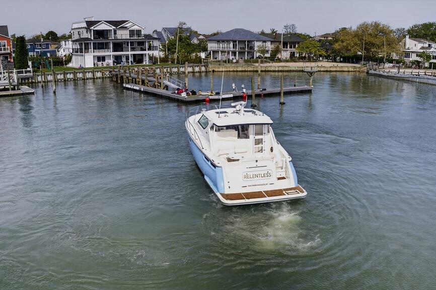 2006 Tiara Yachts 4300 Sovran navigating a calm marina near waterfront homes.