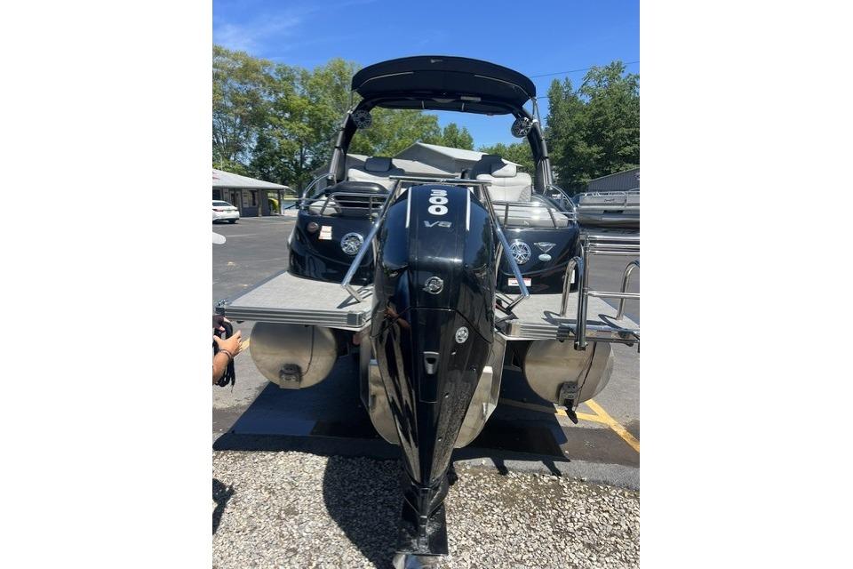 2024 Manitou 25 LX SRW pontoon boat with powerful V8 engine, parked outdoors.