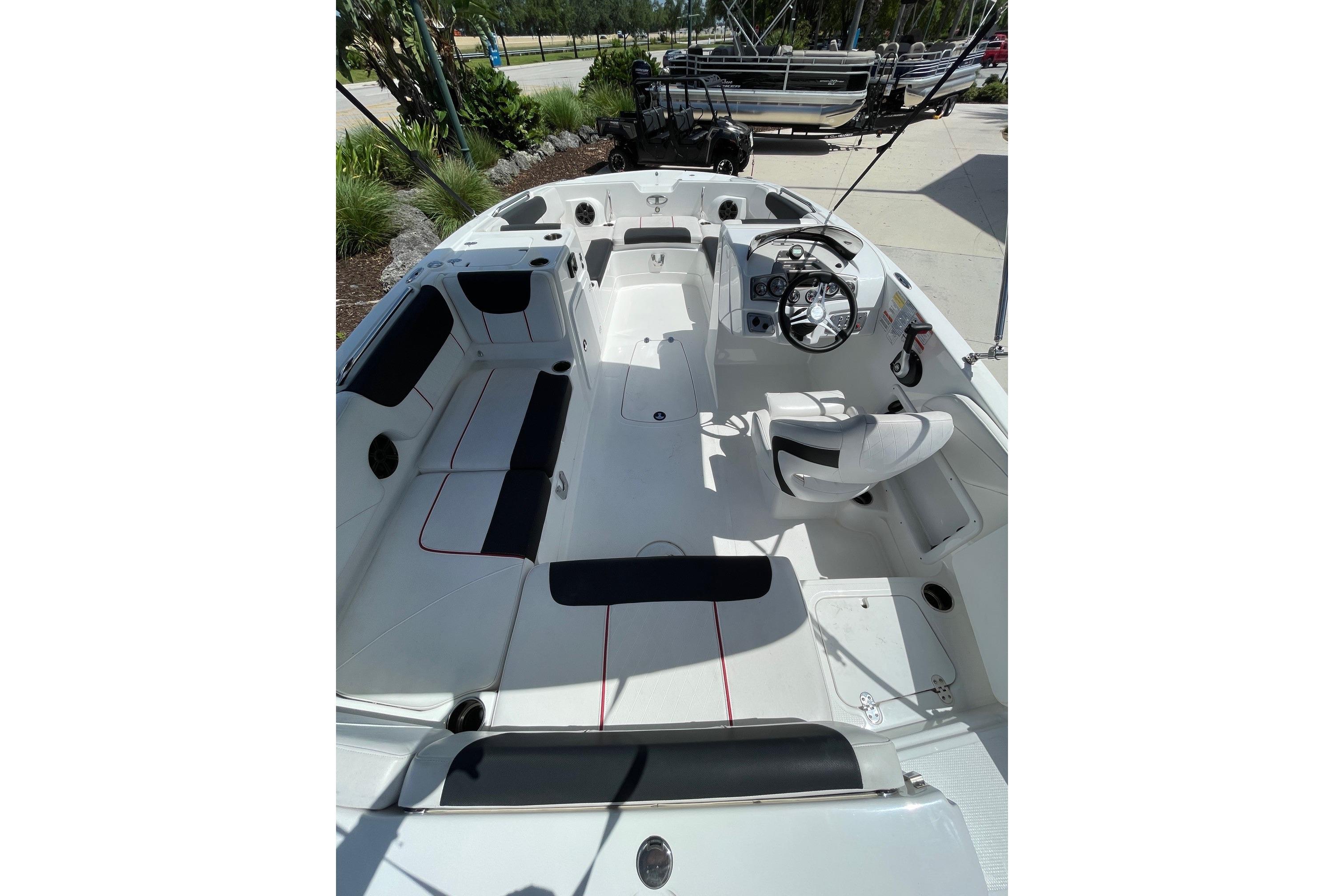 2024 Tahoe 2150 OB boat interior with seating and steering wheel, docked outdoors.