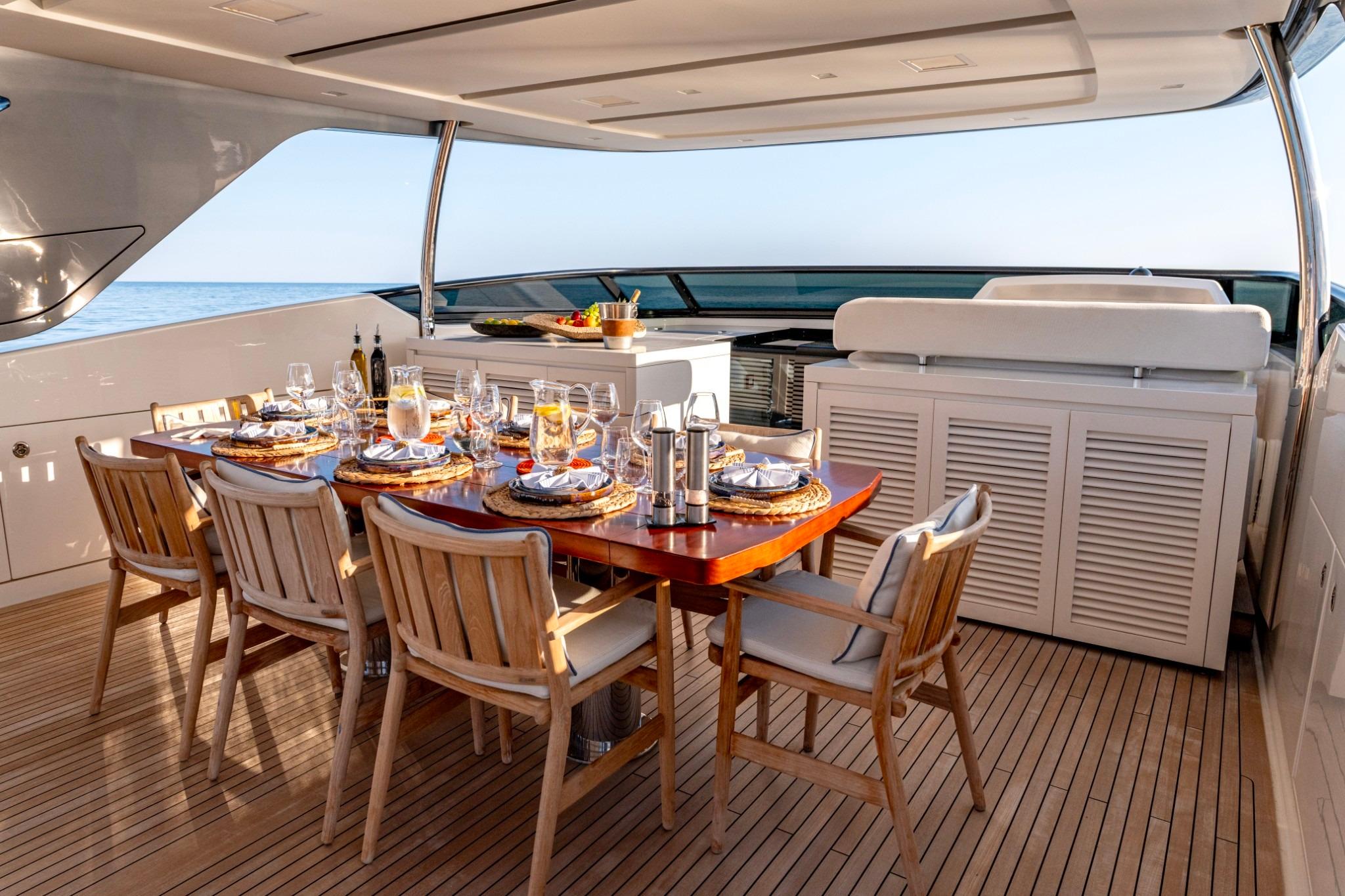 Luxurious dining setup on 2016 Sanlorenzo SL96 yacht deck, featuring elegant tableware and ocean view.