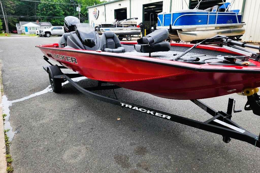 Red 2026 Tracker Pro Team 190 boat on trailer, parked outside a dealership.