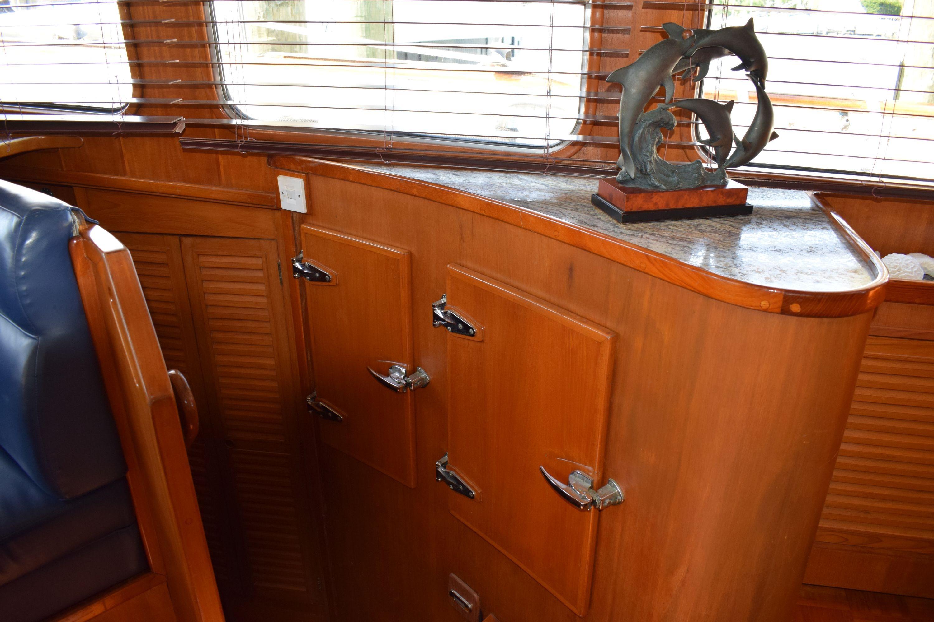 Interior of 1980 Cheoy Lee 52 Motorsailer with wooden cabinetry and dolphin sculpture.