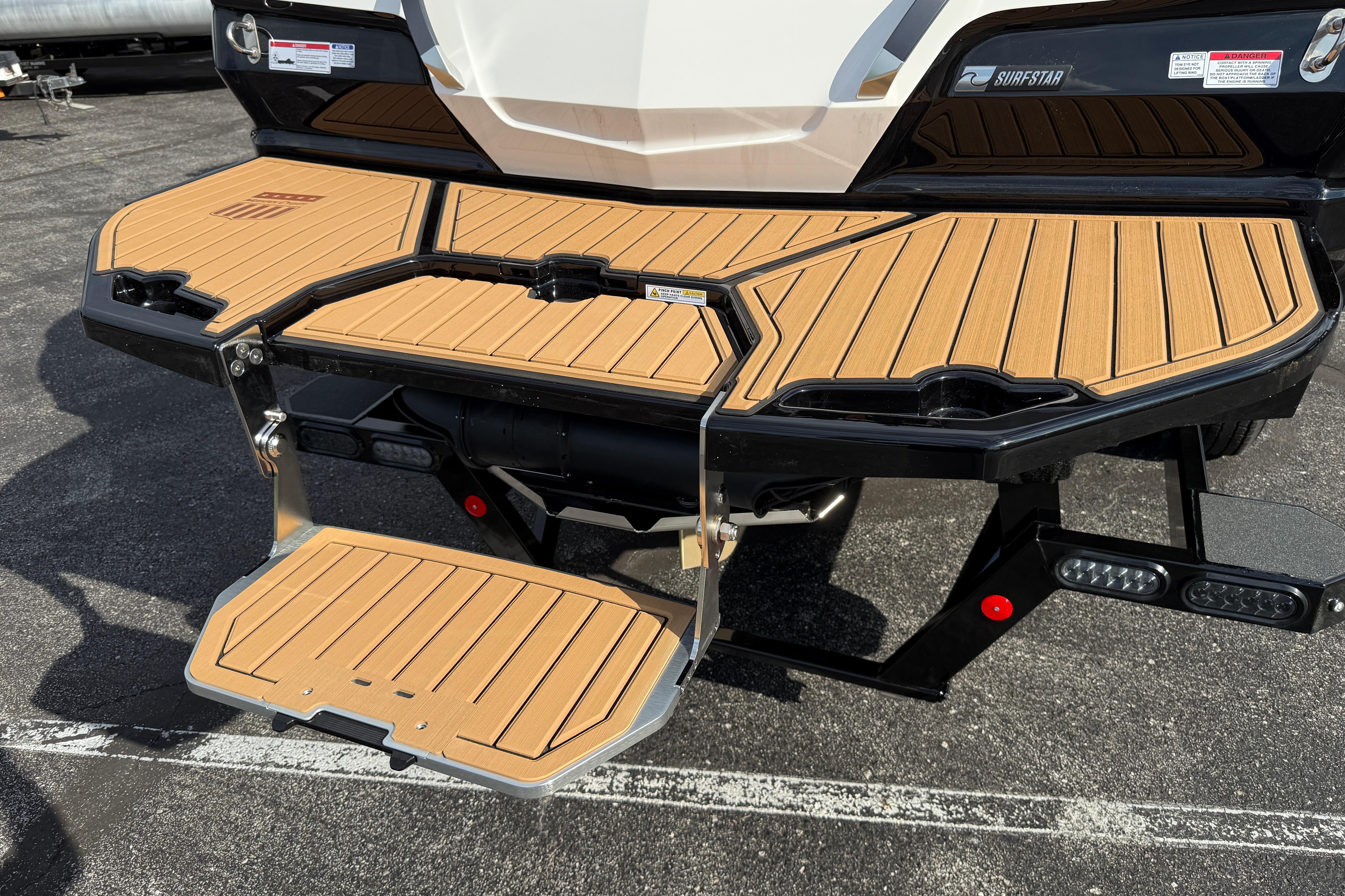 2025 MasterCraft X24 boat with teak swim platform and foldable ladder.