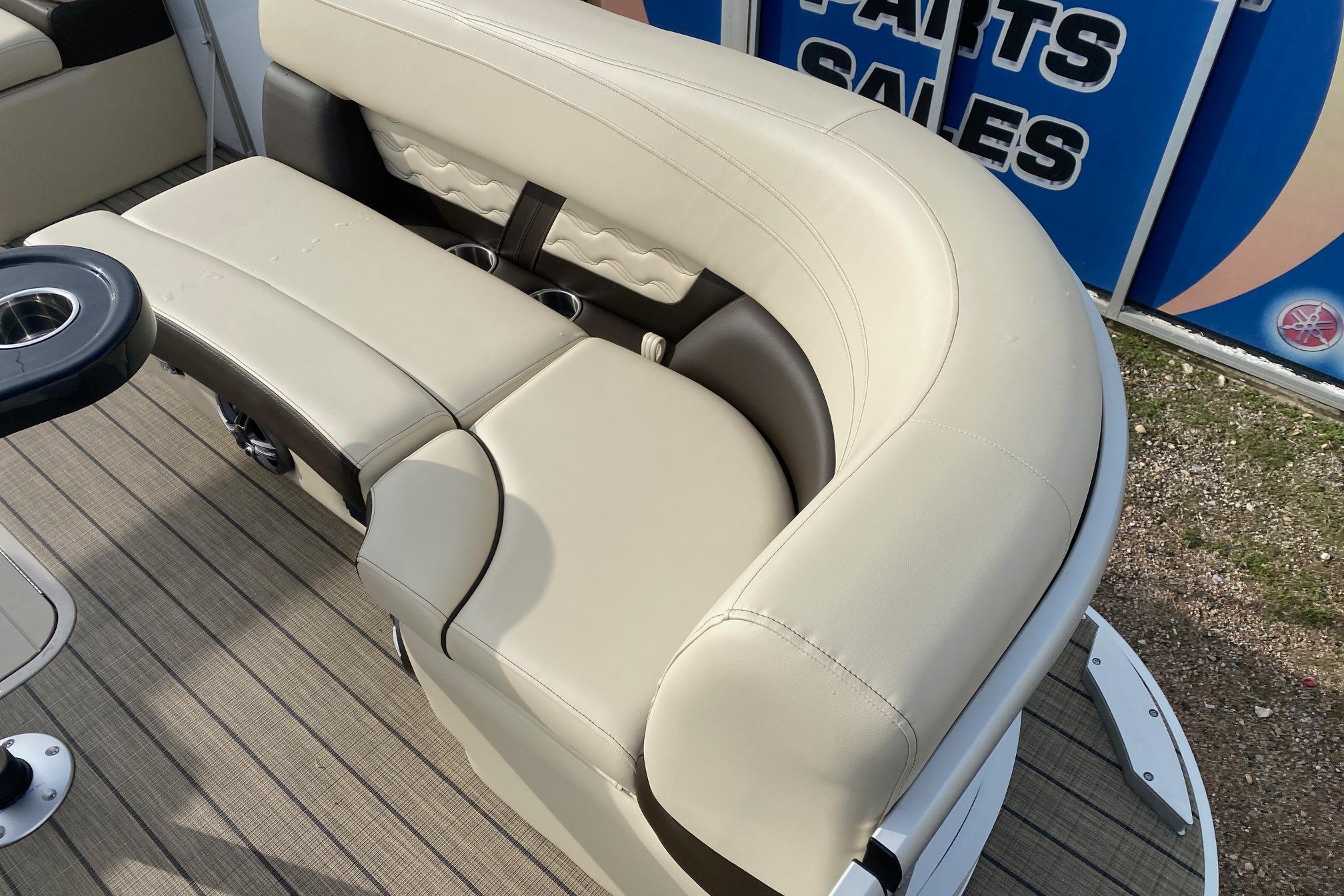 Luxurious seating on 2026 SunCatcher Fusion 324SS boat, featuring beige upholstery and cup holders.