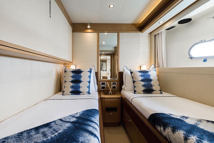 Luxurious twin cabin interior on 2007 Ferretti 830 yacht, featuring elegant bedding and decor.
