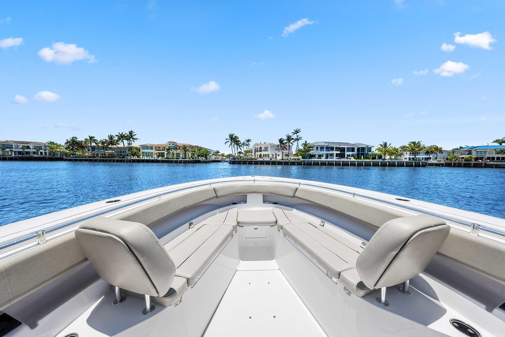 2024 Sportsman Open 352 Center Console boat on calm water, luxury waterfront homes in background.