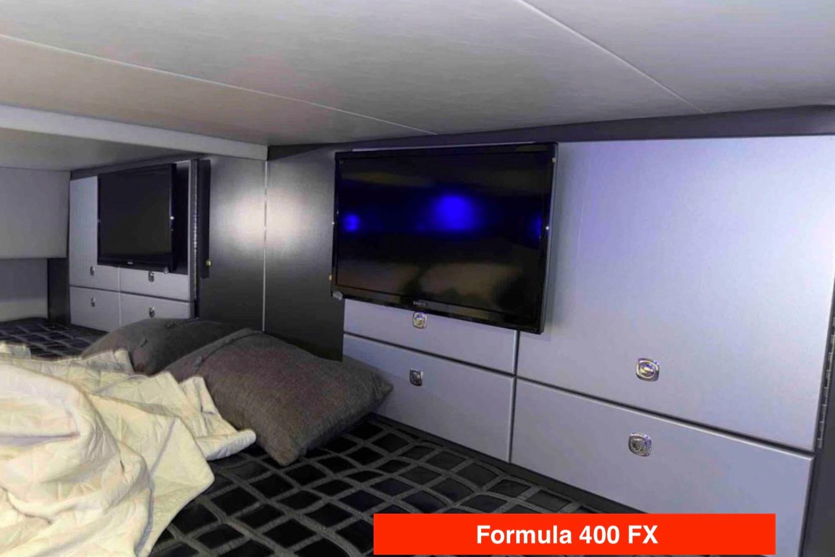 Luxurious interior of 2015 Formula 400 FX yacht with modern TV and bedding.