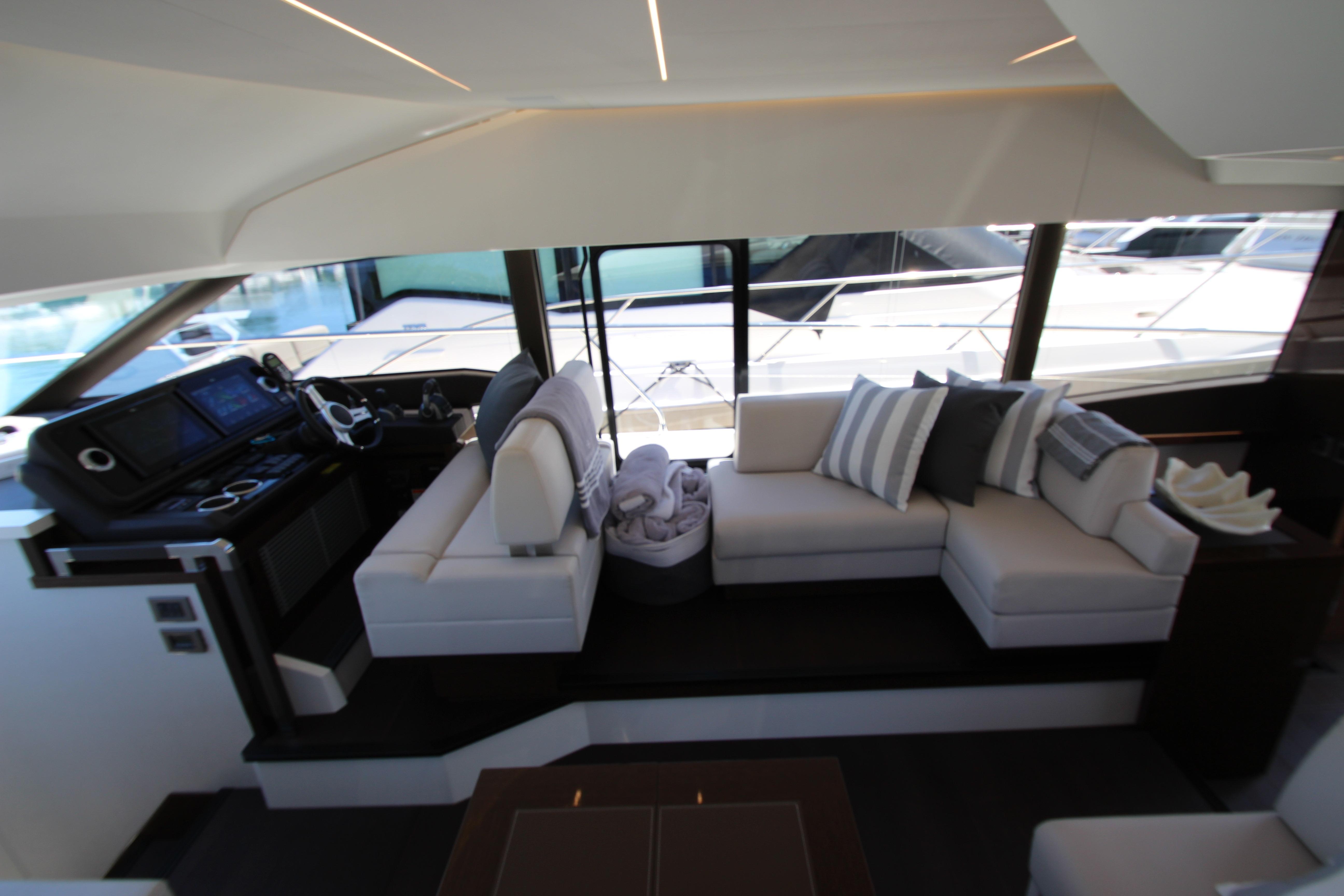 Luxurious interior of 2022 Prestige 520 yacht with modern seating and helm station.