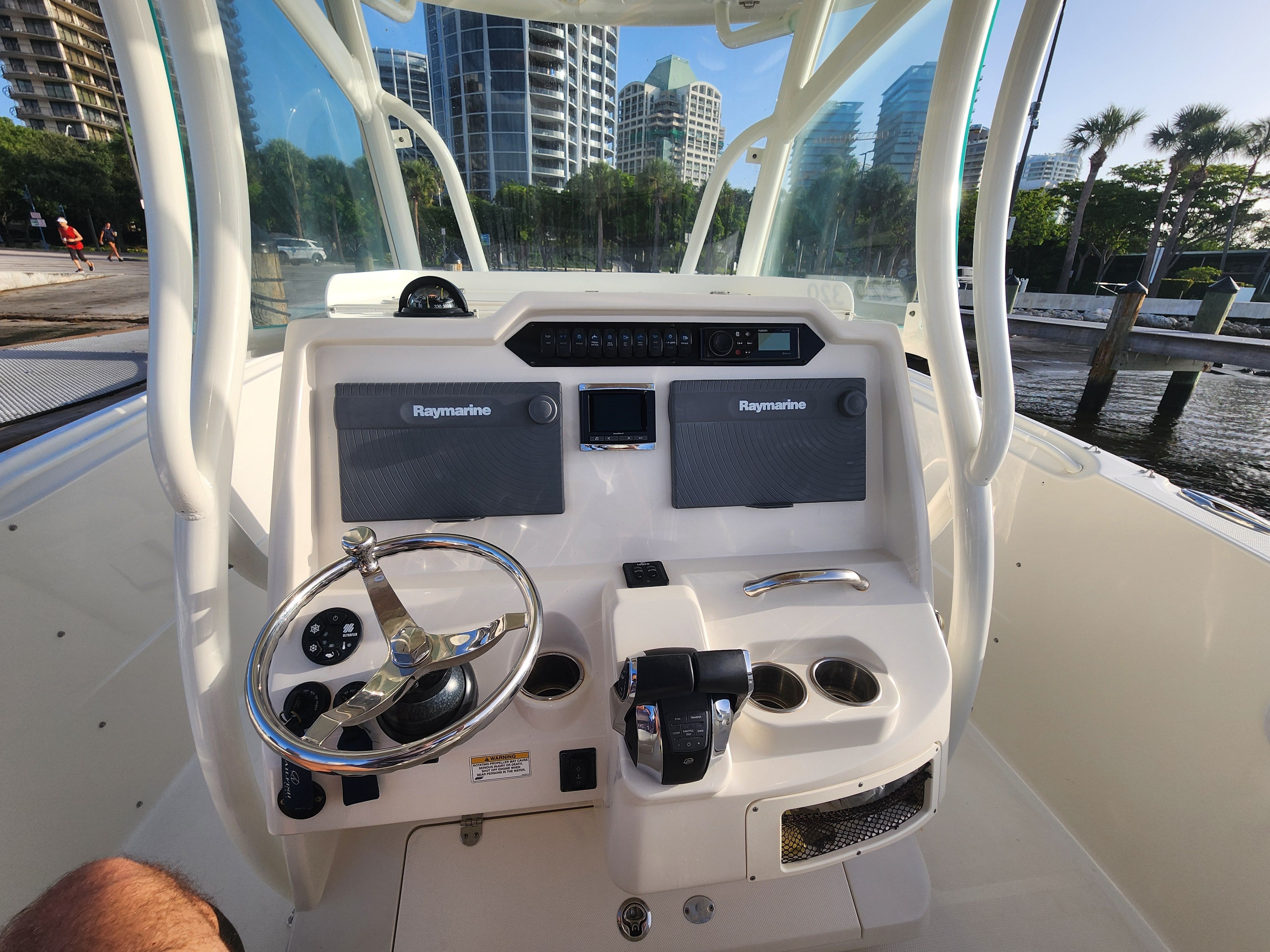 The image shows the helm of a 2017 Sailfish 320 CC with modern instruments and steering wheel.