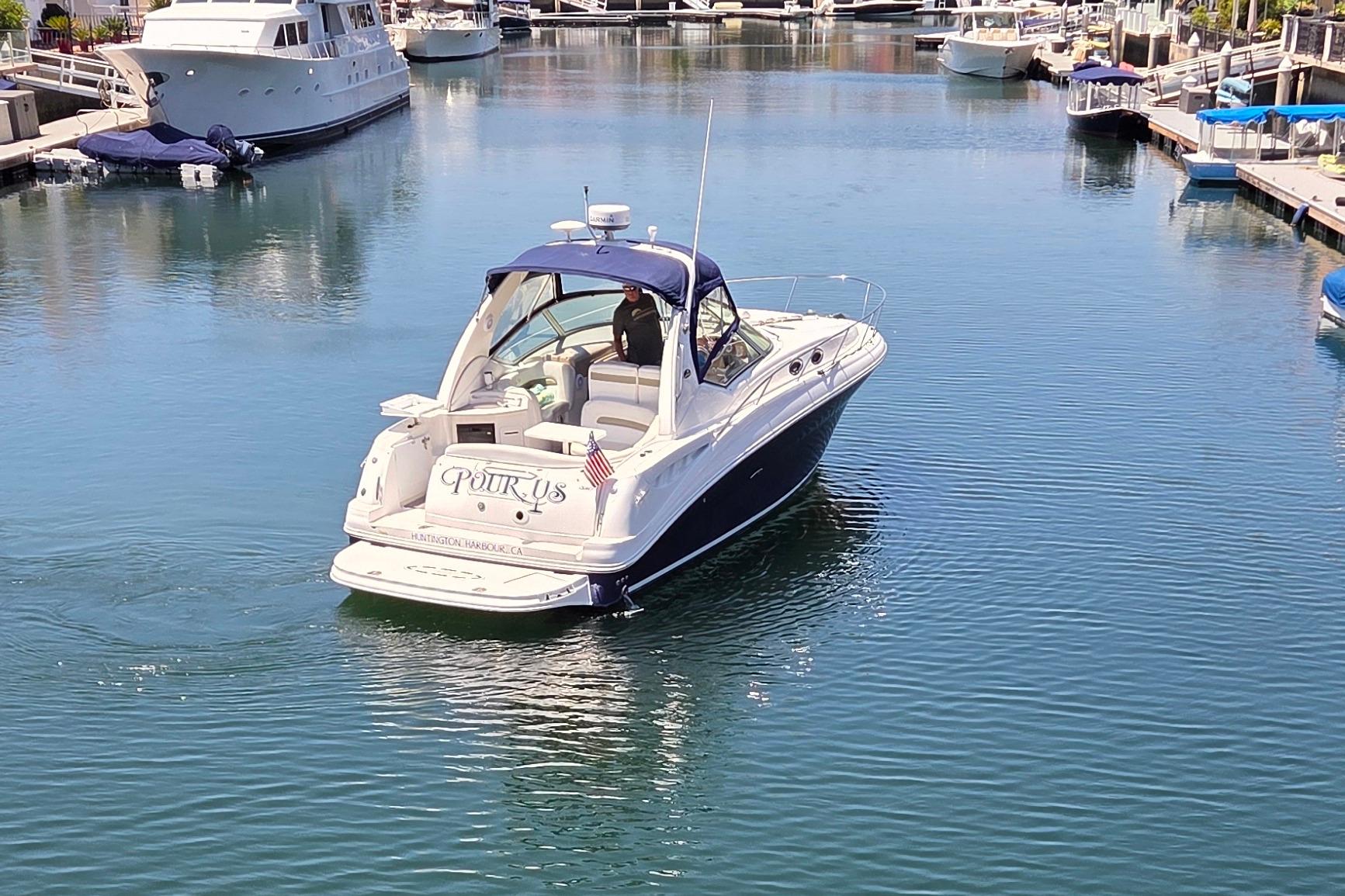 2006 Sea Ray Sundancer 320 yacht cruising in a marina, surrounded by other boats.