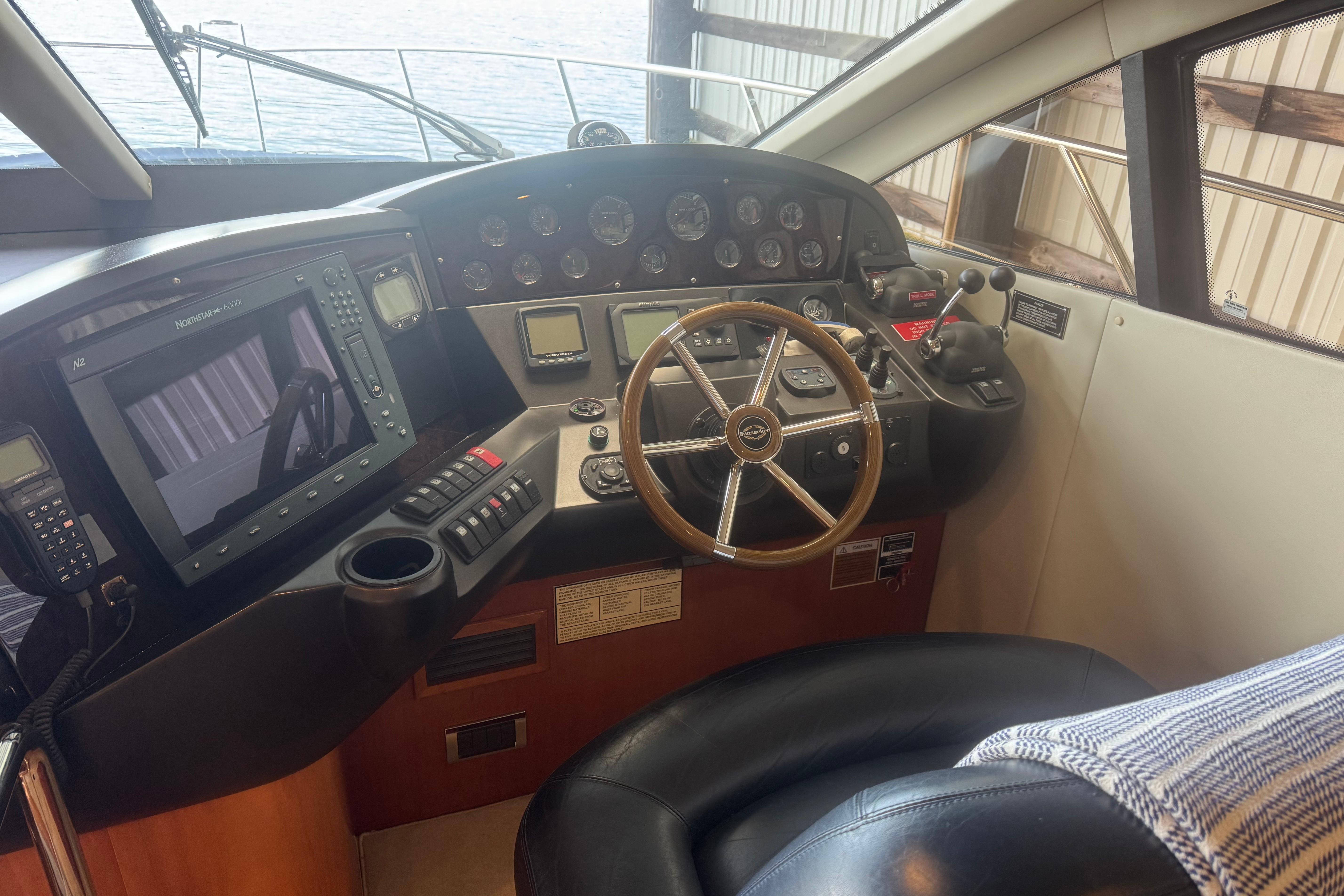 Helm of 2006 Sunseeker Manhattan 50 yacht with steering wheel and navigation controls.