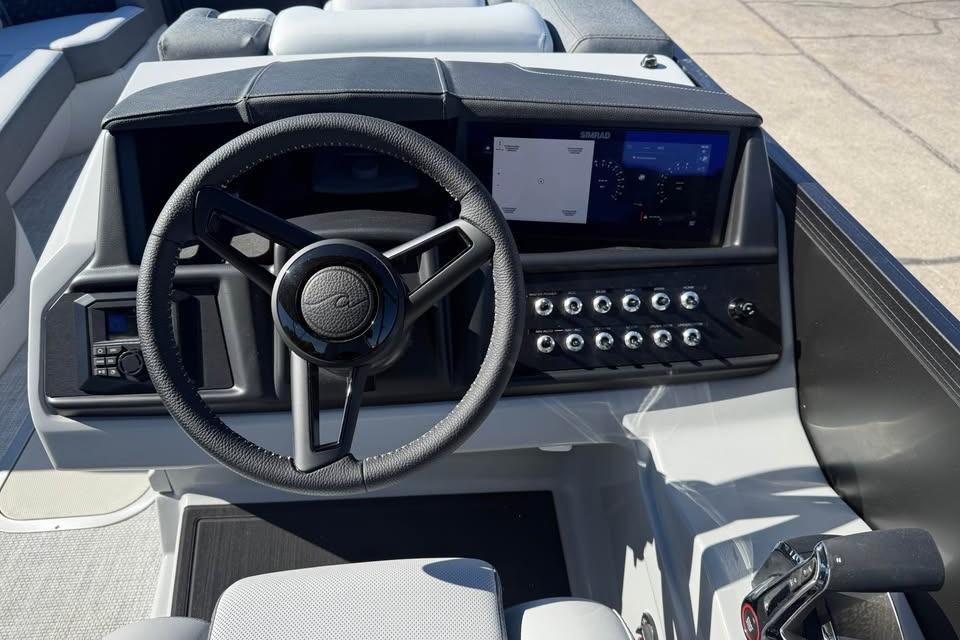 2026 Alera M 25Q boat dashboard with steering wheel and control panel.