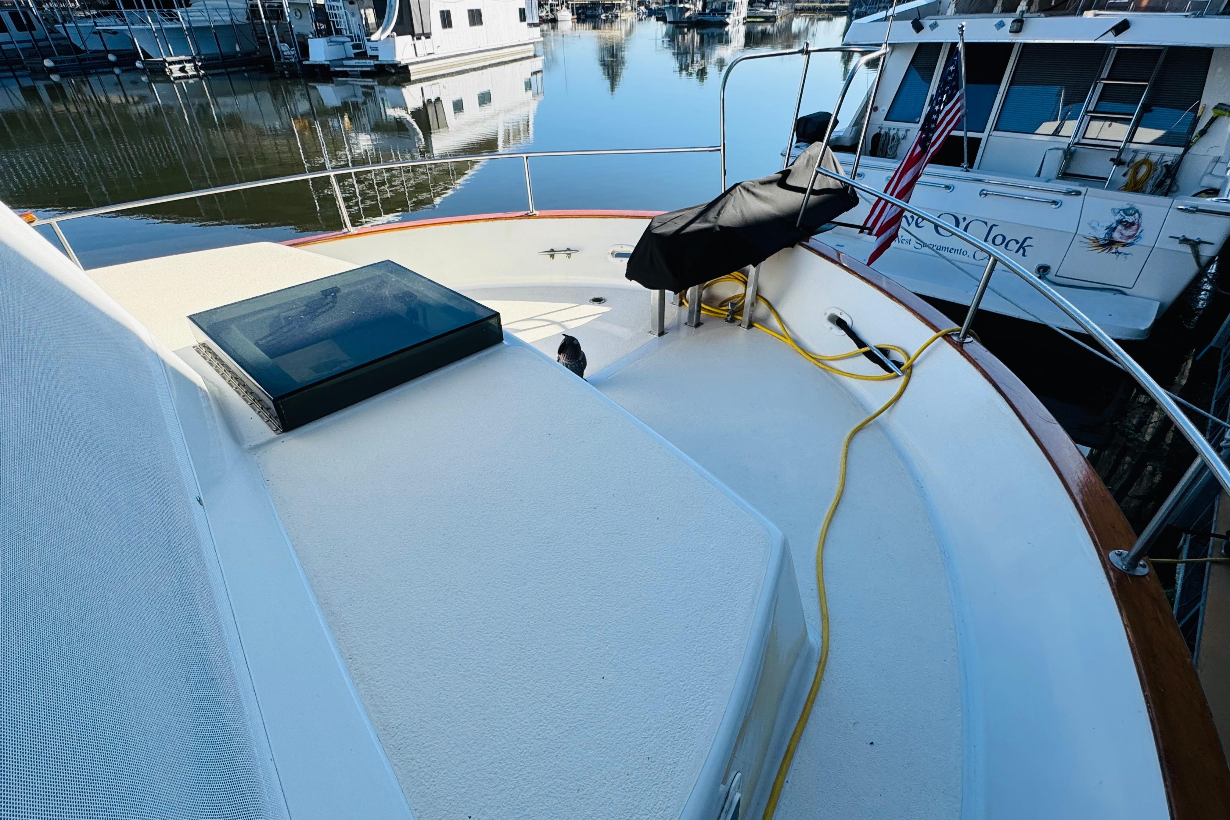 1978 Californian 42 LRC yacht deck with marina view, featuring American flag and docked boats.