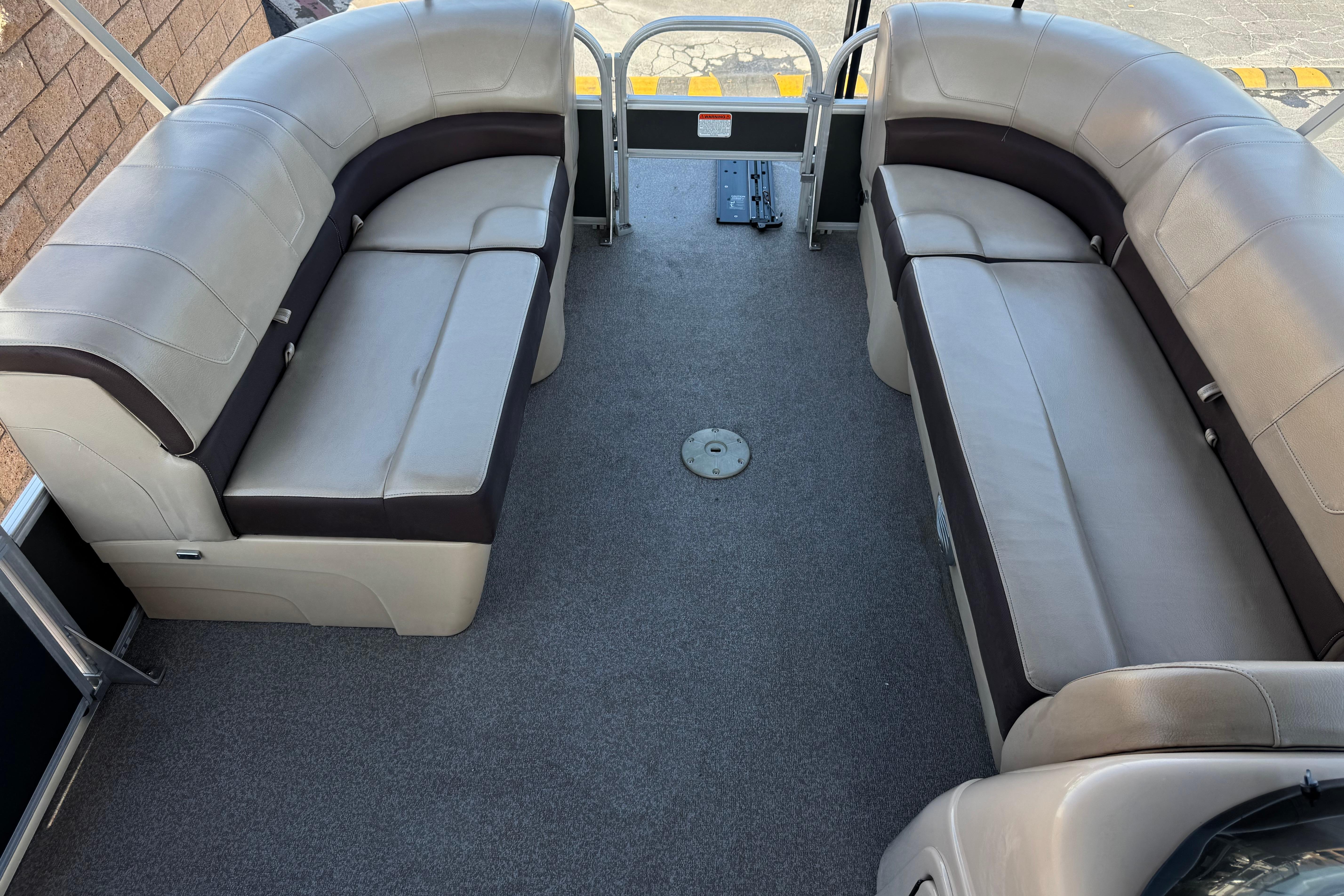2018 Sun Tracker SportFish 22 DLX interior with spacious seating and carpeted flooring.