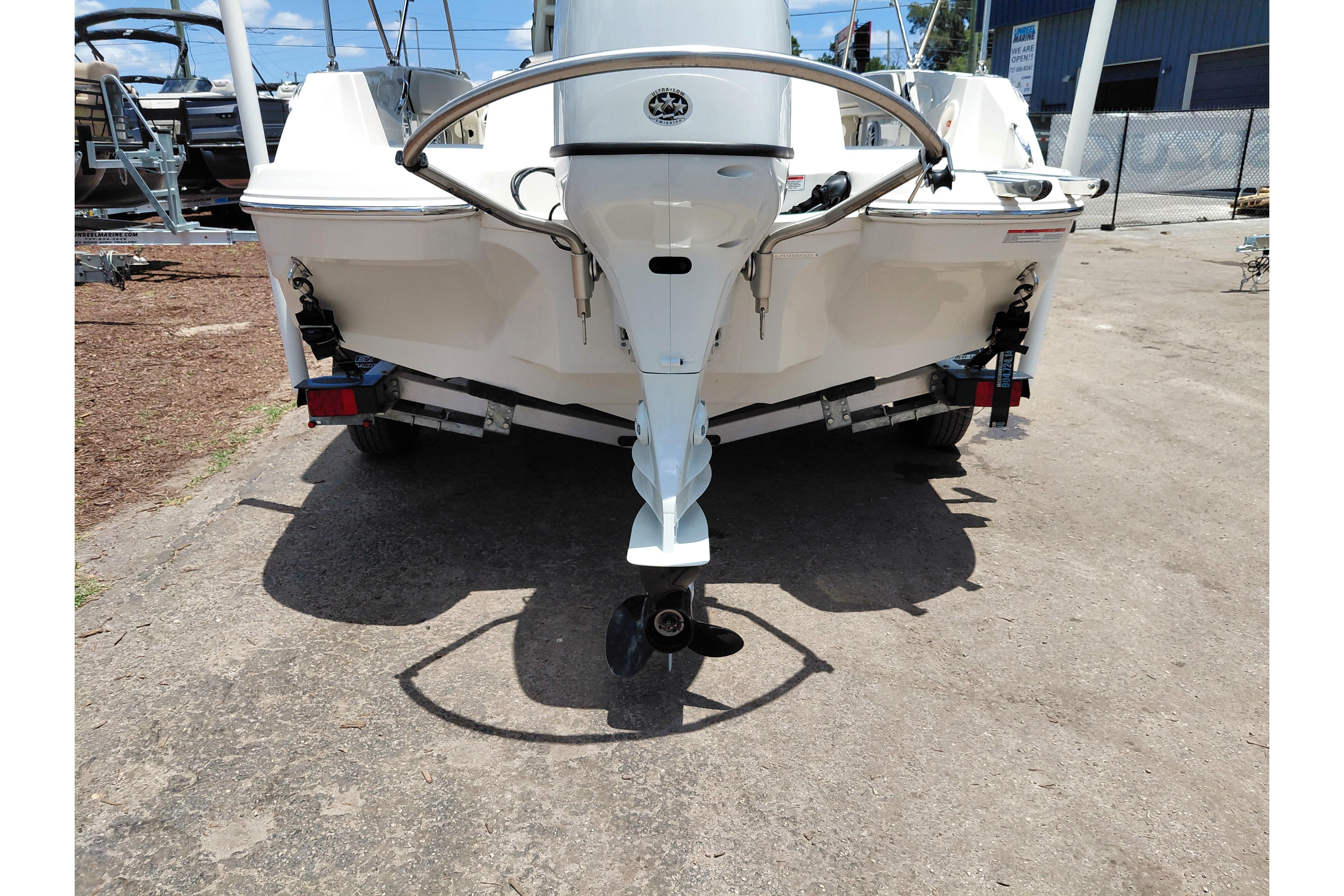 2023 Stingray 206 CC boat rear view with outboard motor in a marina setting.