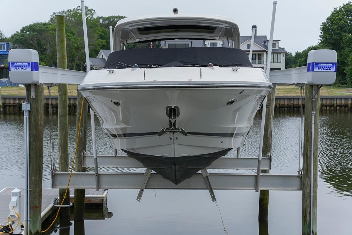 2018 Sea Ray SLX 350 boat on lift, docked by waterfront homes.