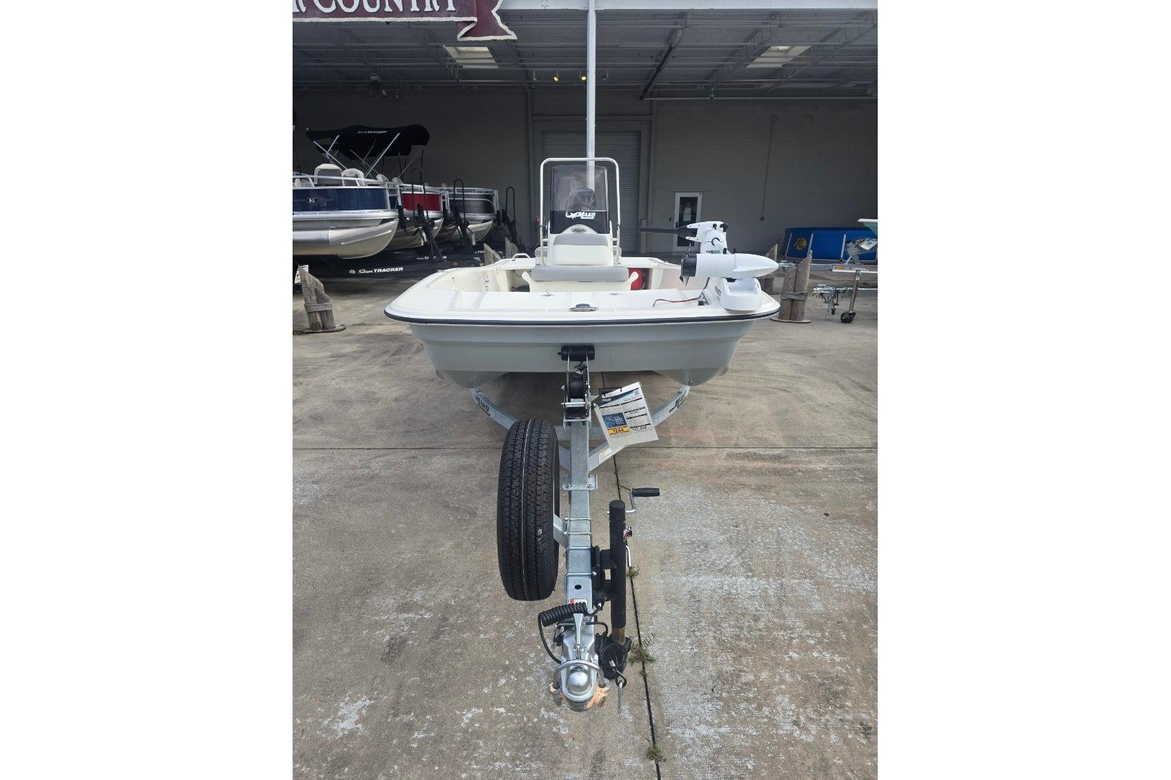2026 Mako Pro Skiff 15 CC boat on trailer in a showroom setting.
