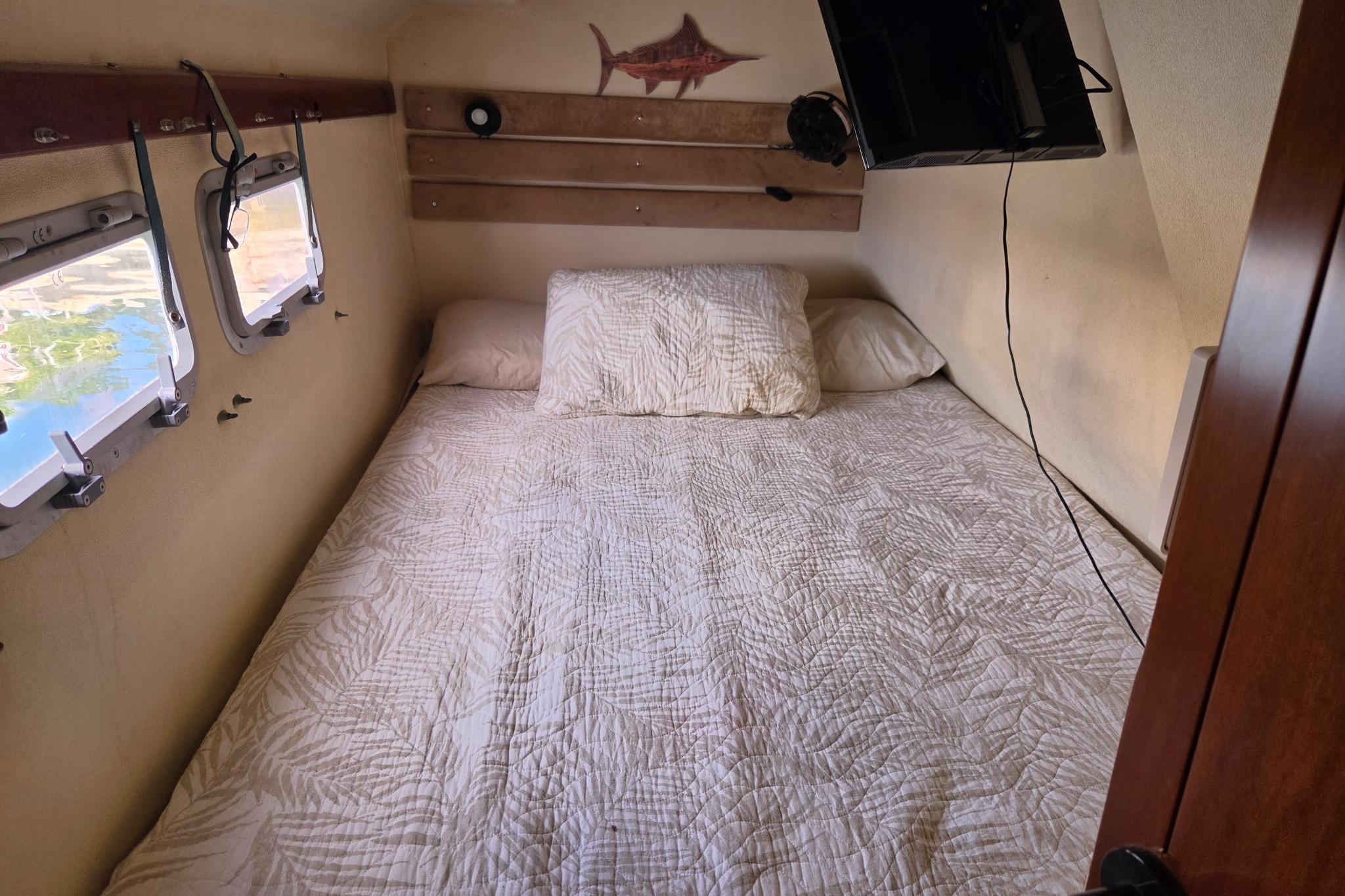 Cozy cabin bedroom in 2000 Fountaine Pajot Maryland 37 yacht with quilted bedding.