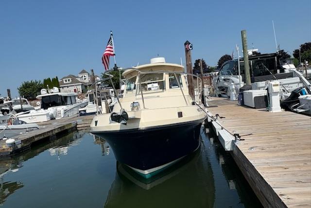 2003 Albin 28 Tournament Express docked at a marina with American flag.