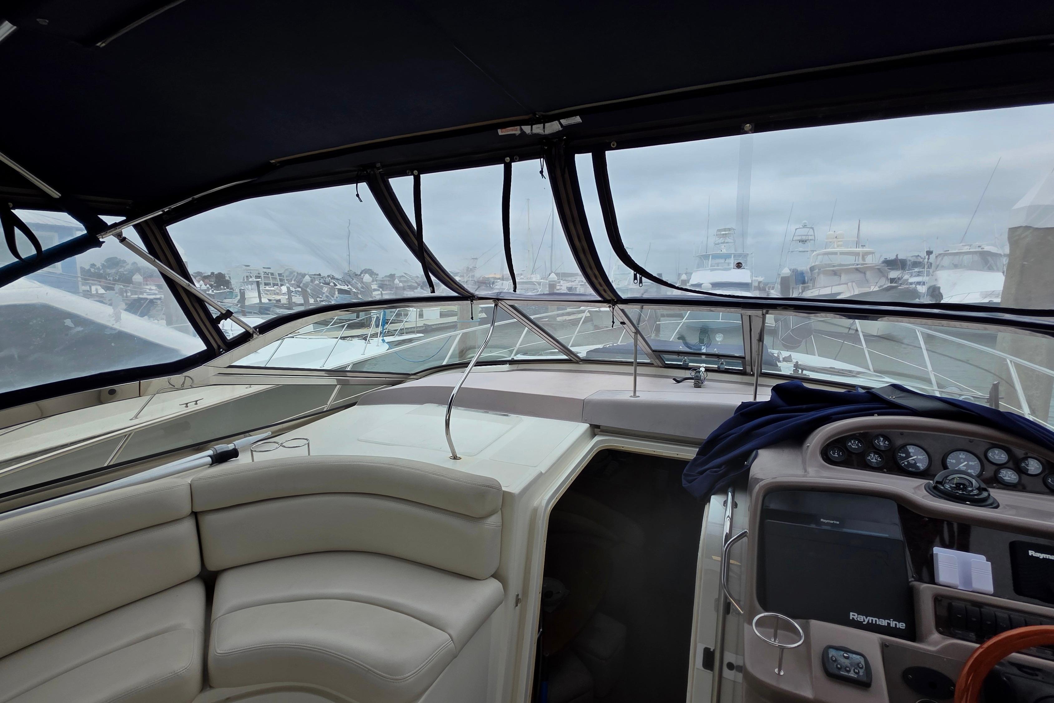 2002 Regal Commodore 4260 yacht interior with helm, seating, and marina view.