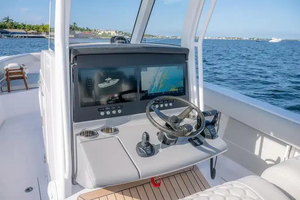 Manufacturer Provided Image: Helm of 2026 Jupiter 340LS boat with advanced navigation screens on open water.