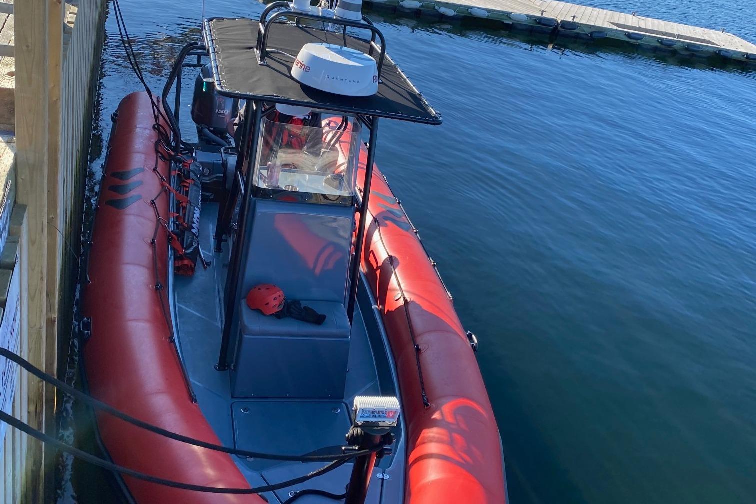 2021 Zodiac Pro 750 boat docked on calm water, featuring red and gray design.