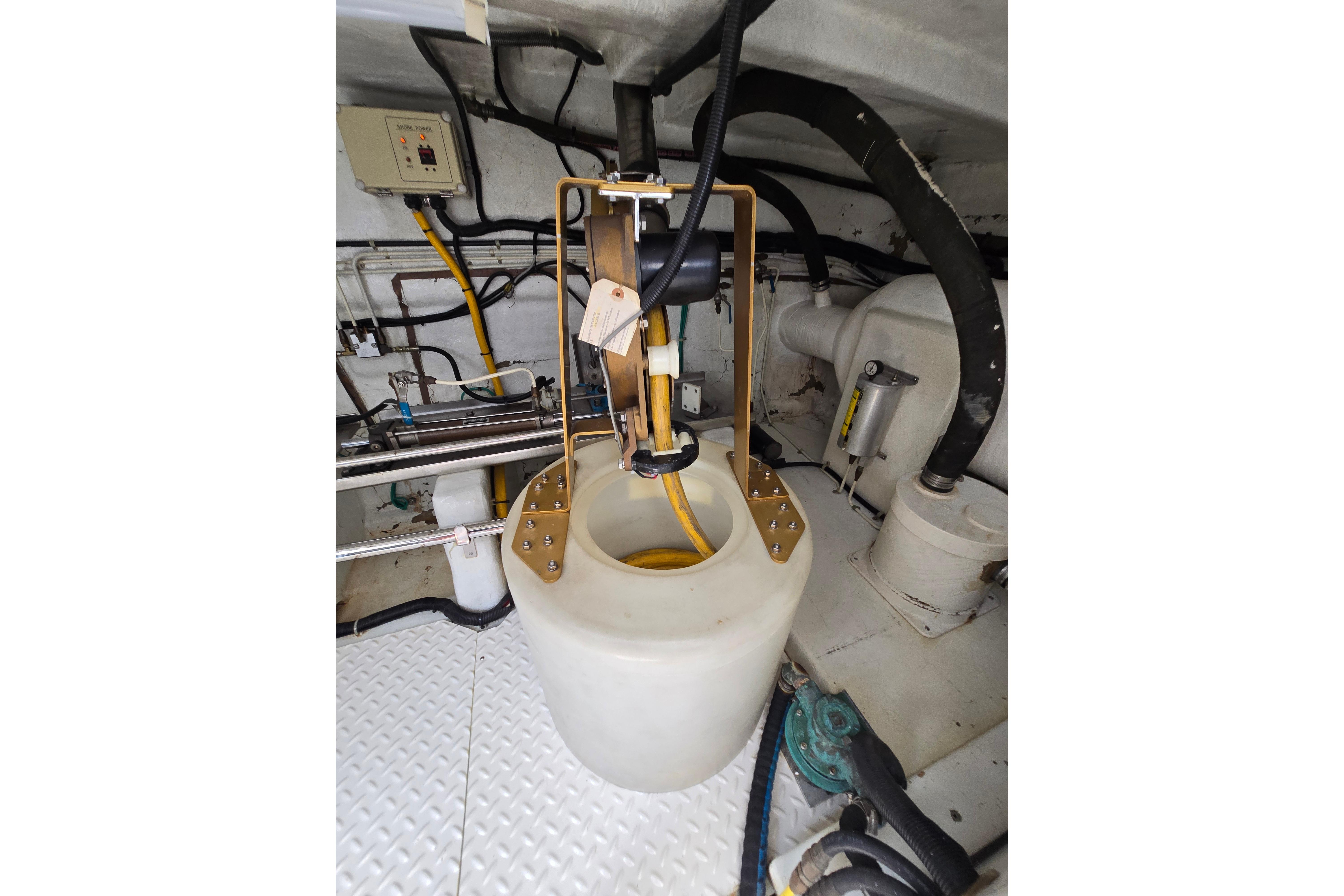 Engine room of 2004 Grand Harbour 58 yacht, featuring mechanical components and piping.