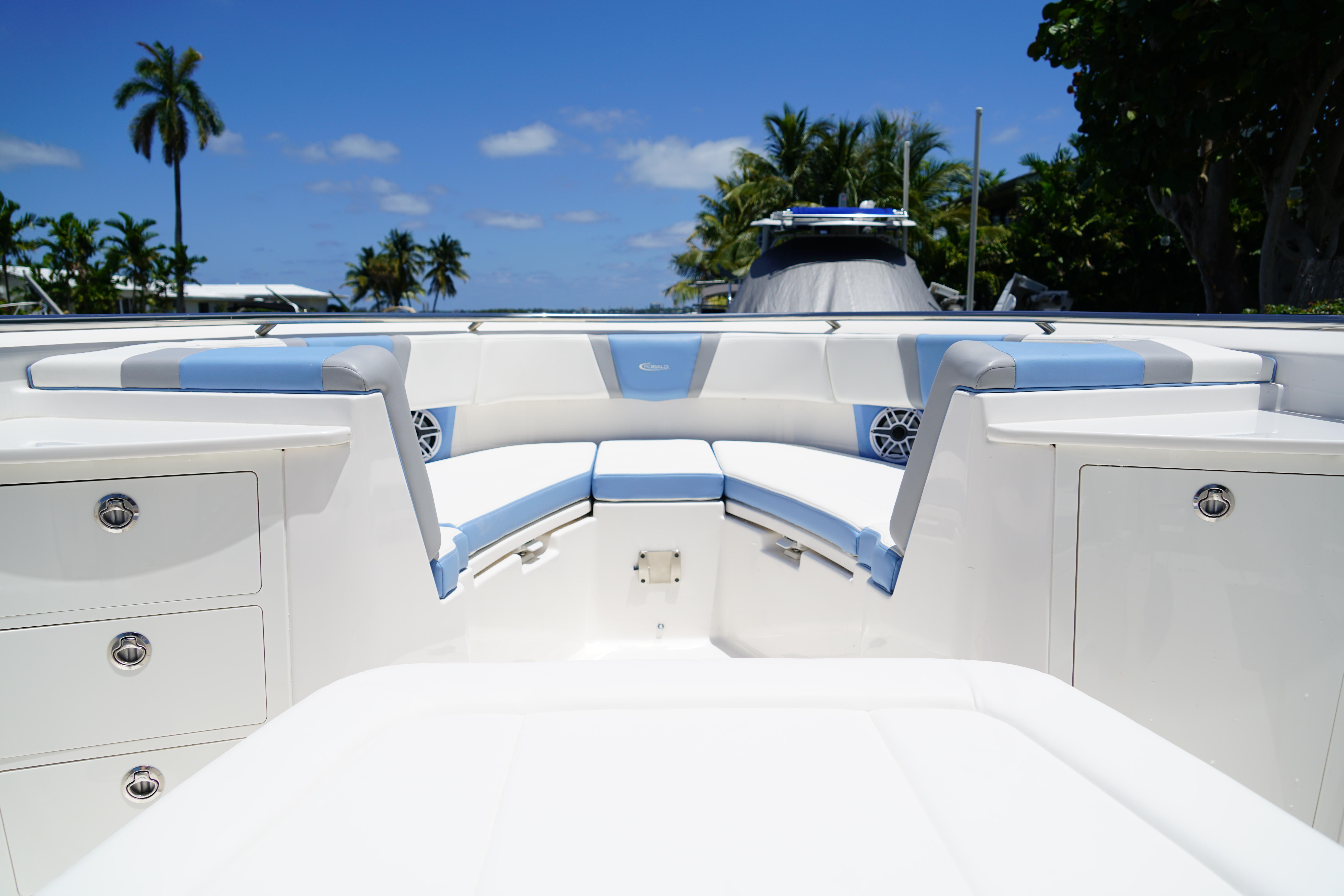 2024 Robalo R360 Center Console boat interior with seating and storage, under clear blue sky.