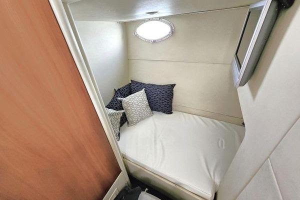 Cozy cabin interior of 2005 Sunseeker Manhattan 66 yacht with bed and pillows.
