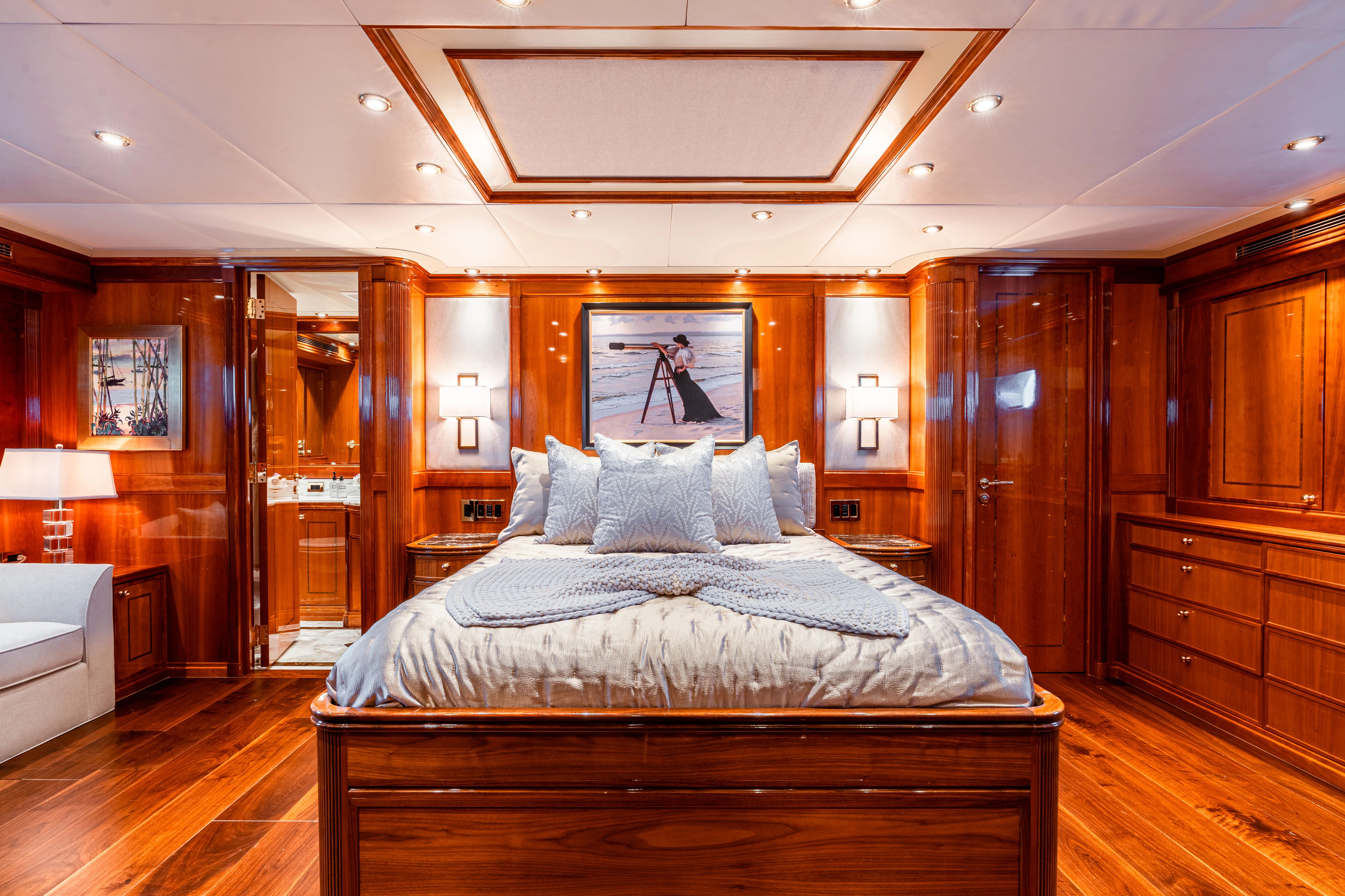 Luxurious bedroom with wooden walls and a large bed, surrounded by elegant lighting.