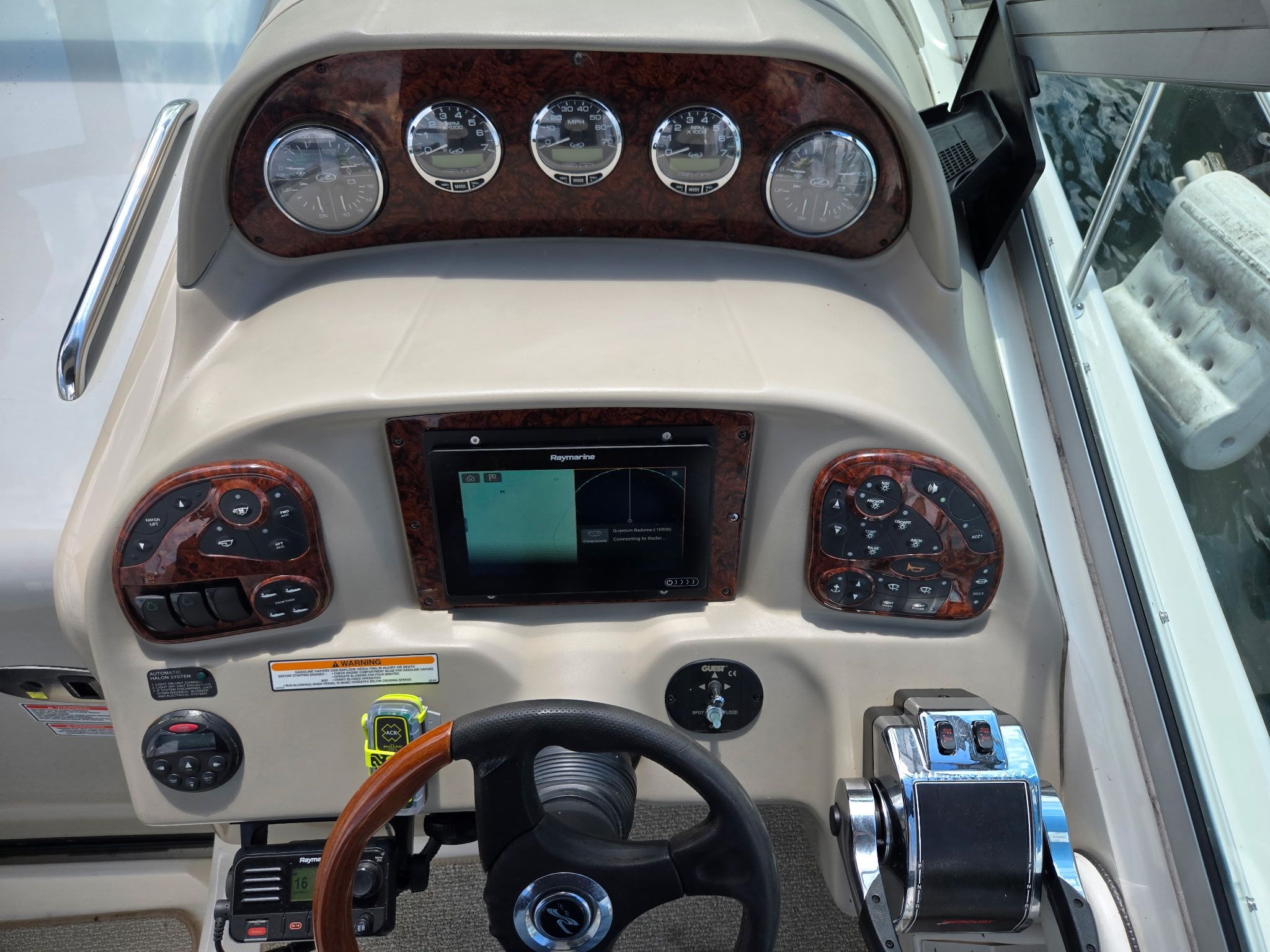 The dashboard of a 2006 Sea Ray 300 Sundancer with wood trim and modern instruments.