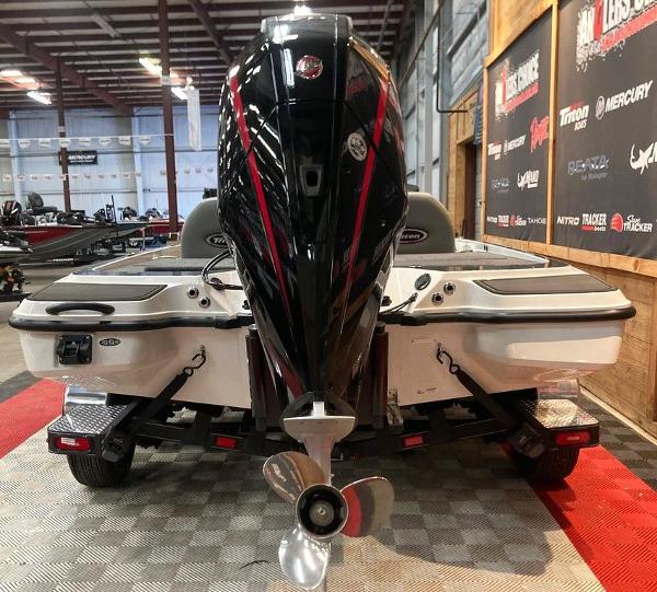 2025 Triton 20XP boat in showroom, rear view with powerful outboard motor.