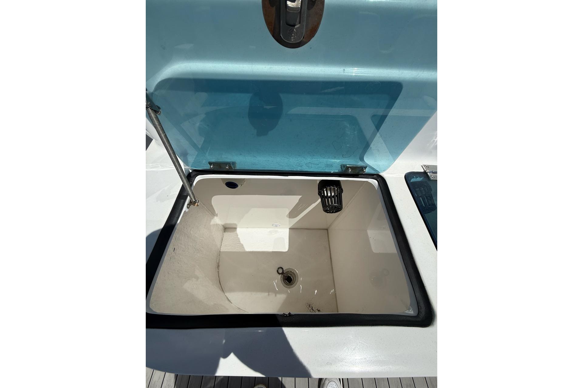 Open storage compartment on 2021 Custom Infusion 34 CC boat, featuring a blue lid.