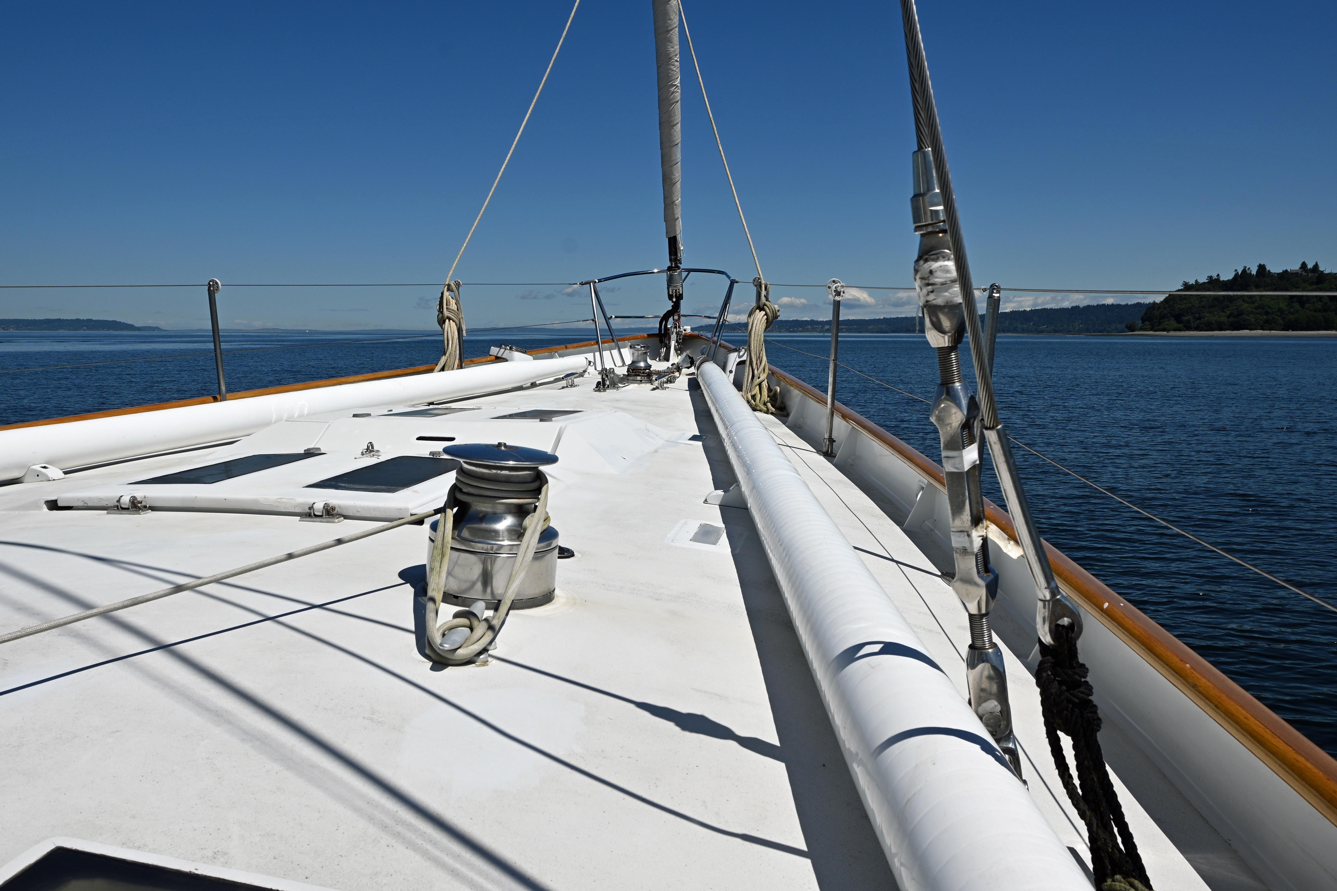 Sailing yacht deck view, Abeking & Rasmussen Tripp 74, 1968, on calm blue waters.
