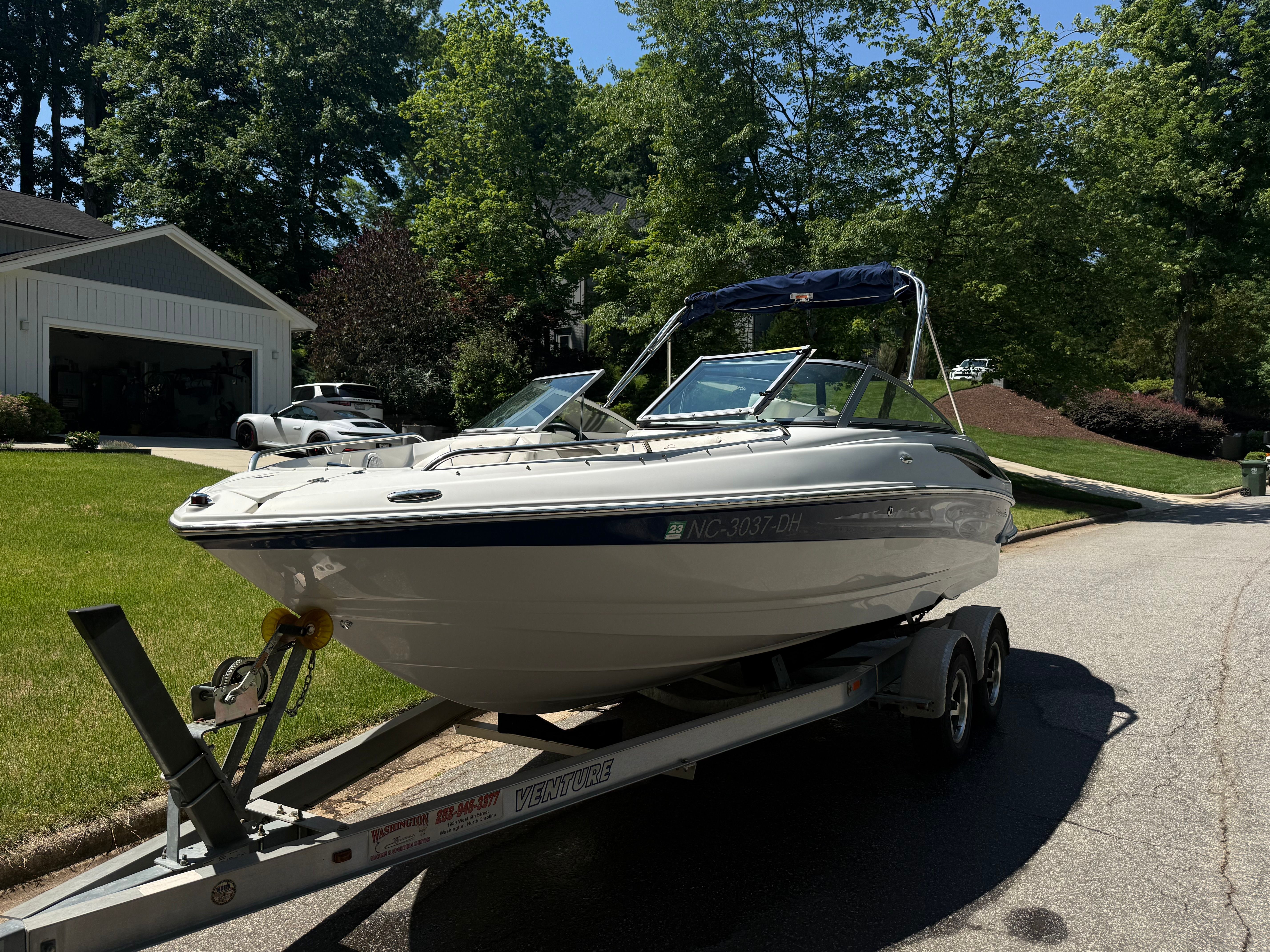 2008 Crownline 210 LX boat on trailer in residential area.