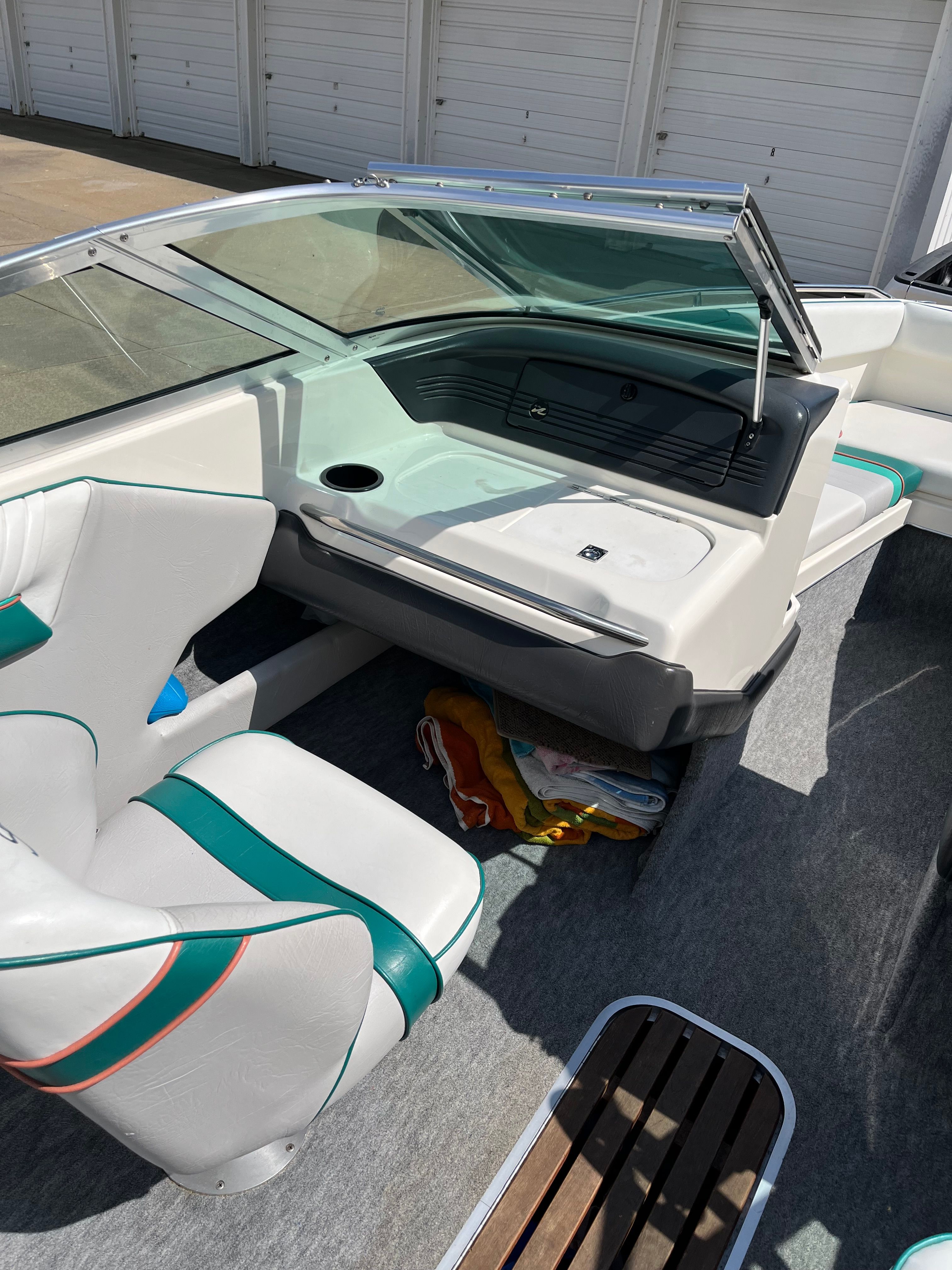 A 1992 Sea Ray 220 Bow Rider with white seats and turquoise accents.